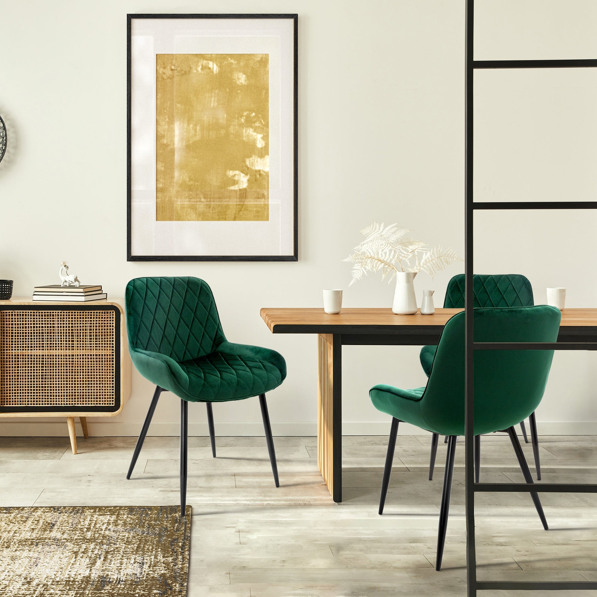 Salle à manger avec des chaises vertes, une table et une œuvre murale dorée.