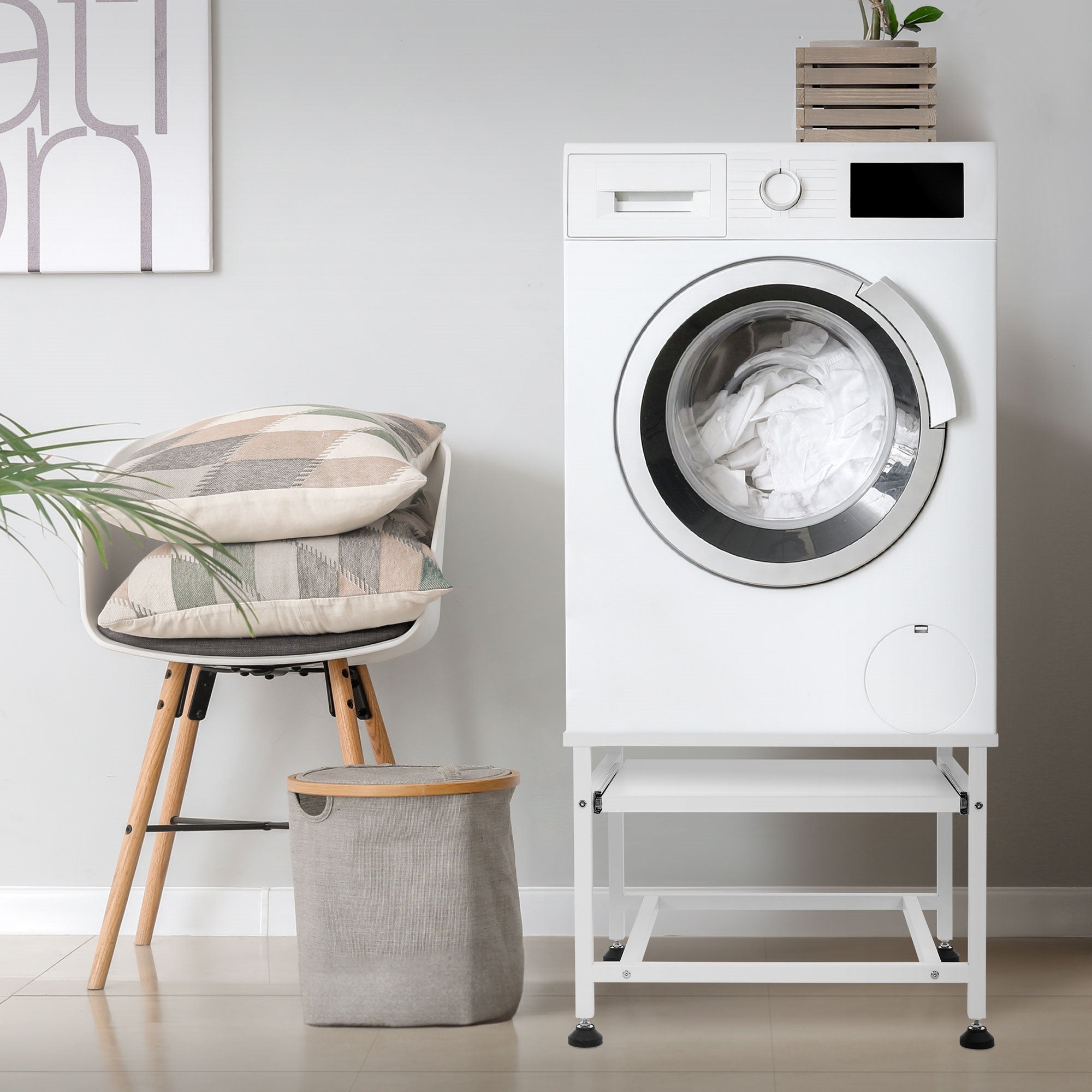 Wasmachine op een onderbouw met kussen en wasmand in de ruimte.