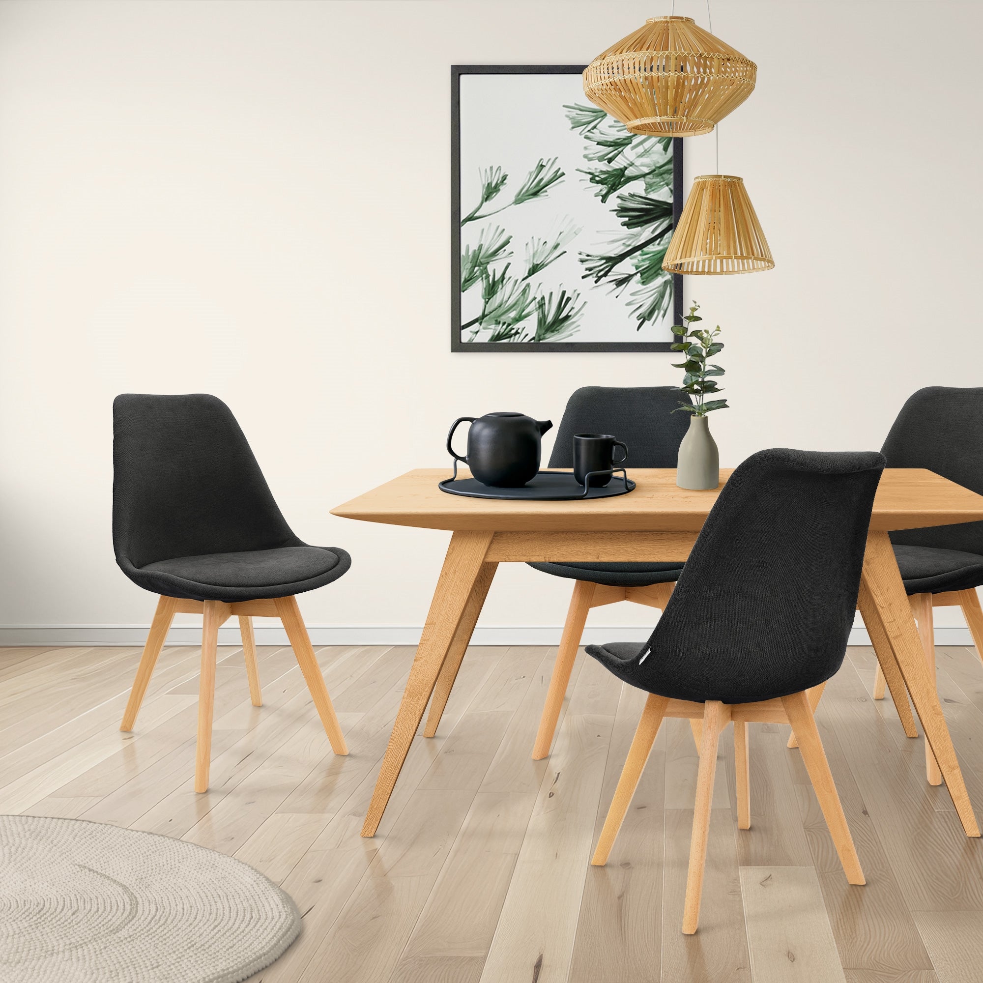 Esszimmer mit einem Holztisch und vier schwarzen Stühlen.