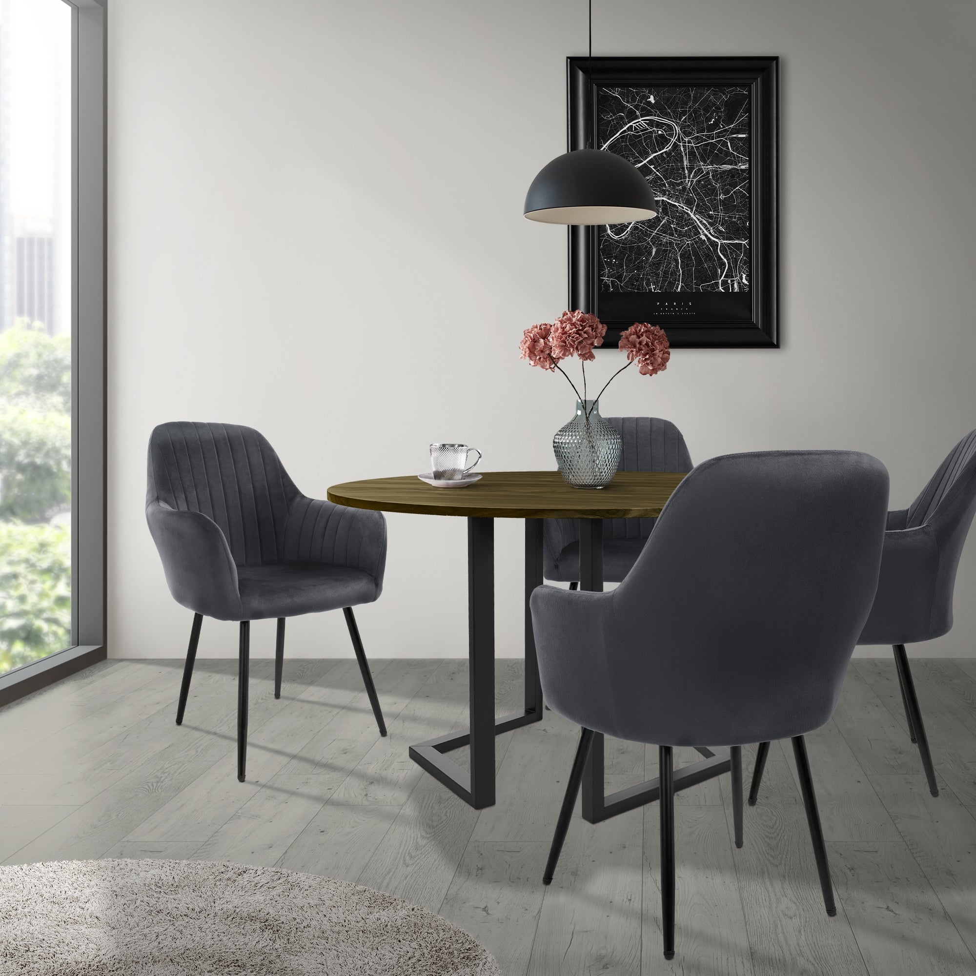 Tres sillas grises alrededor de una mesa redonda con flores y decoración.