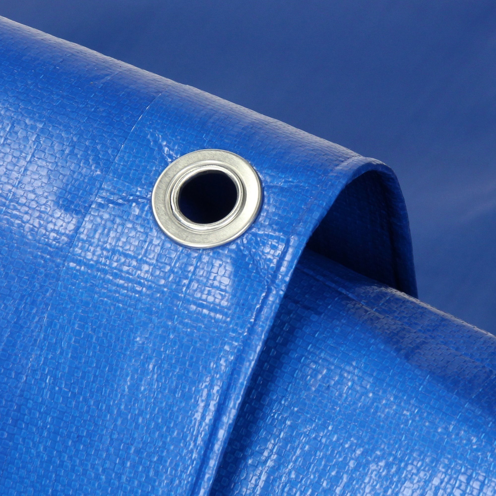 Close-up of a blue tarpaulin with an eyelet hole.