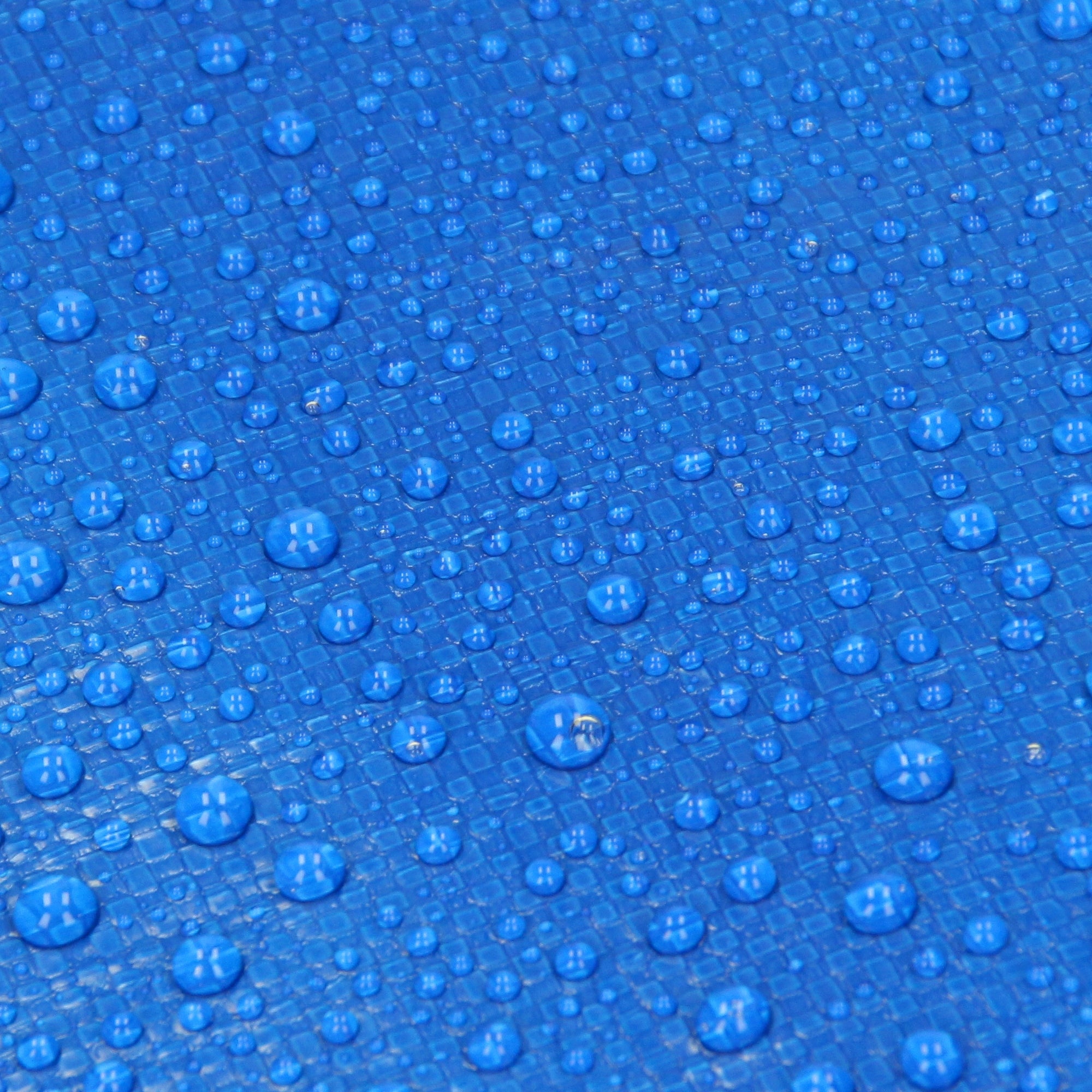 Nahaufnahme einer blauen Plane mit Wassertropfen auf der Oberfläche.