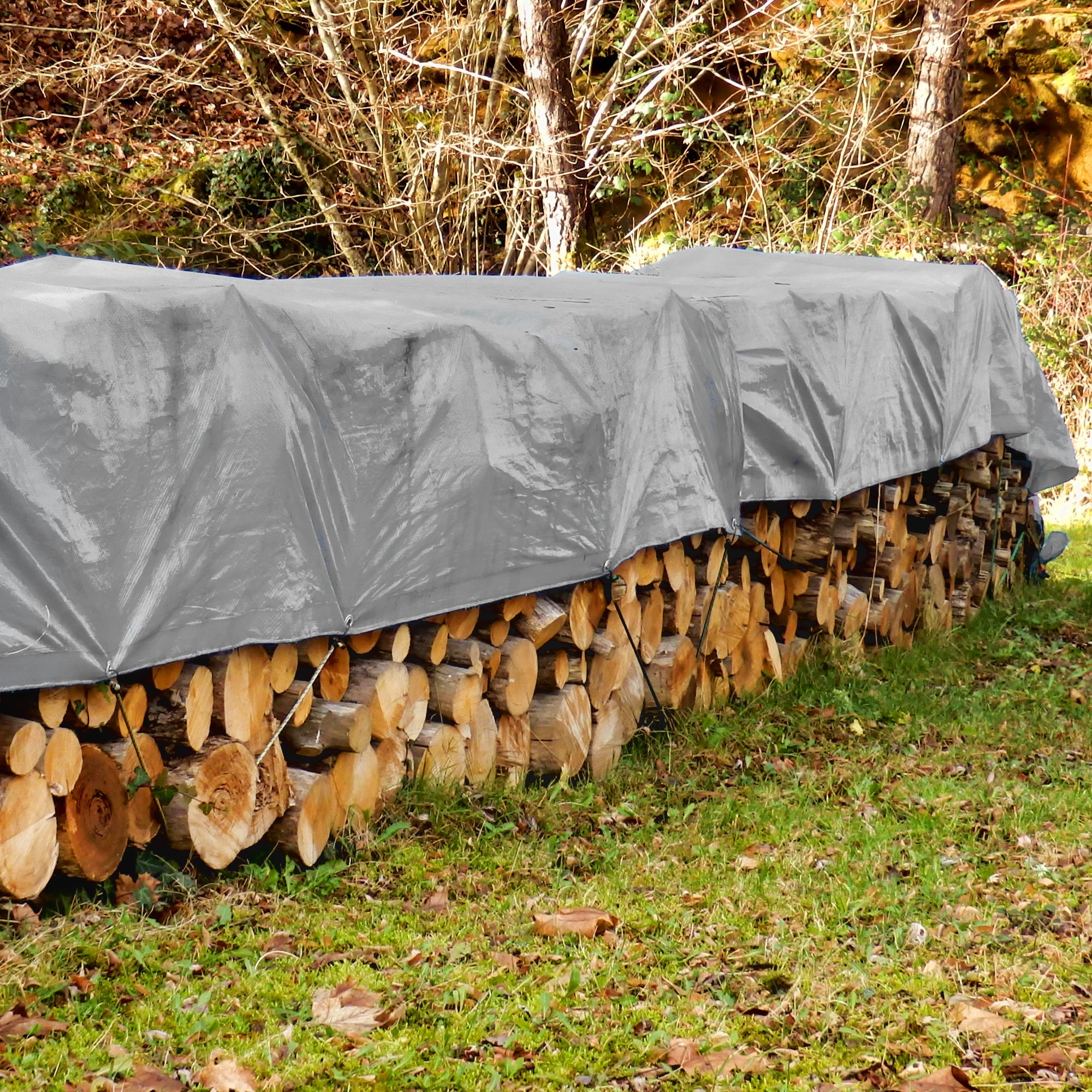 Graue Plane, die Holzstämme vor Regen schützt, im Freien.