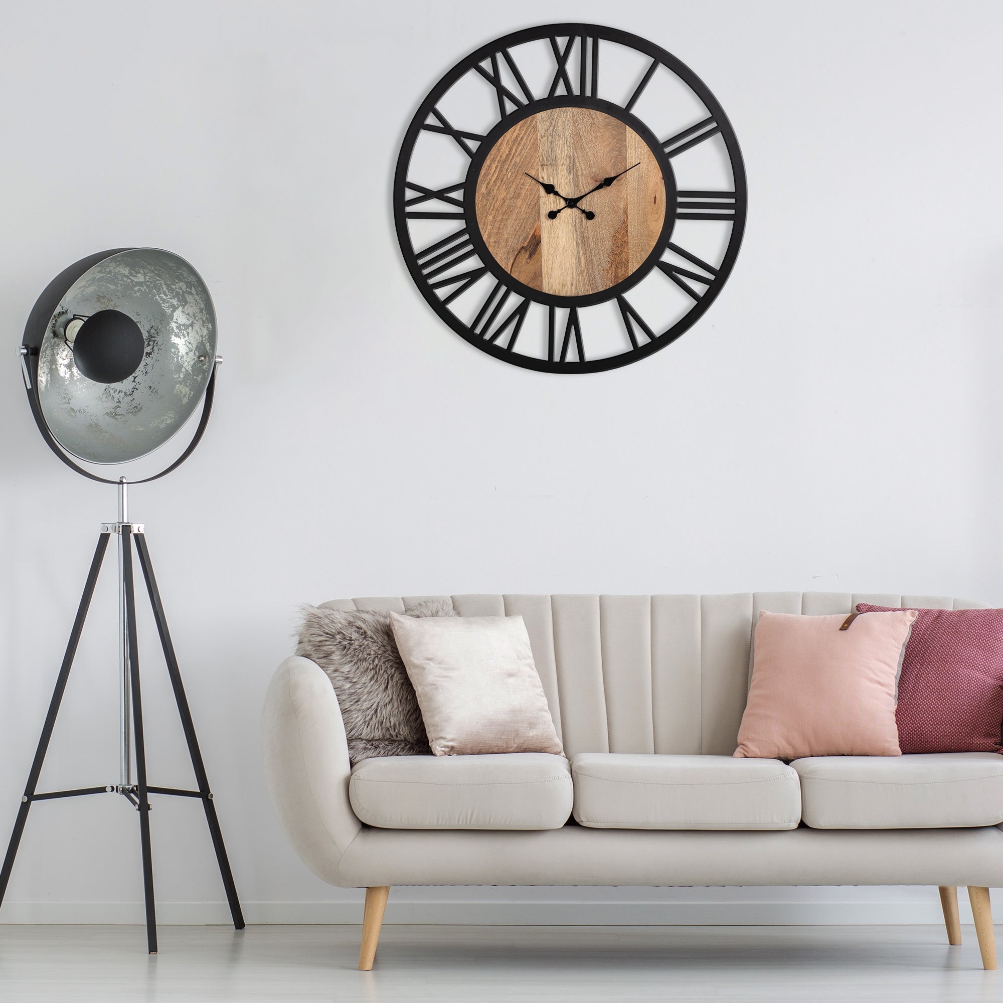 Una sala de estar moderna con un reloj de pared negro y un sofá claro.