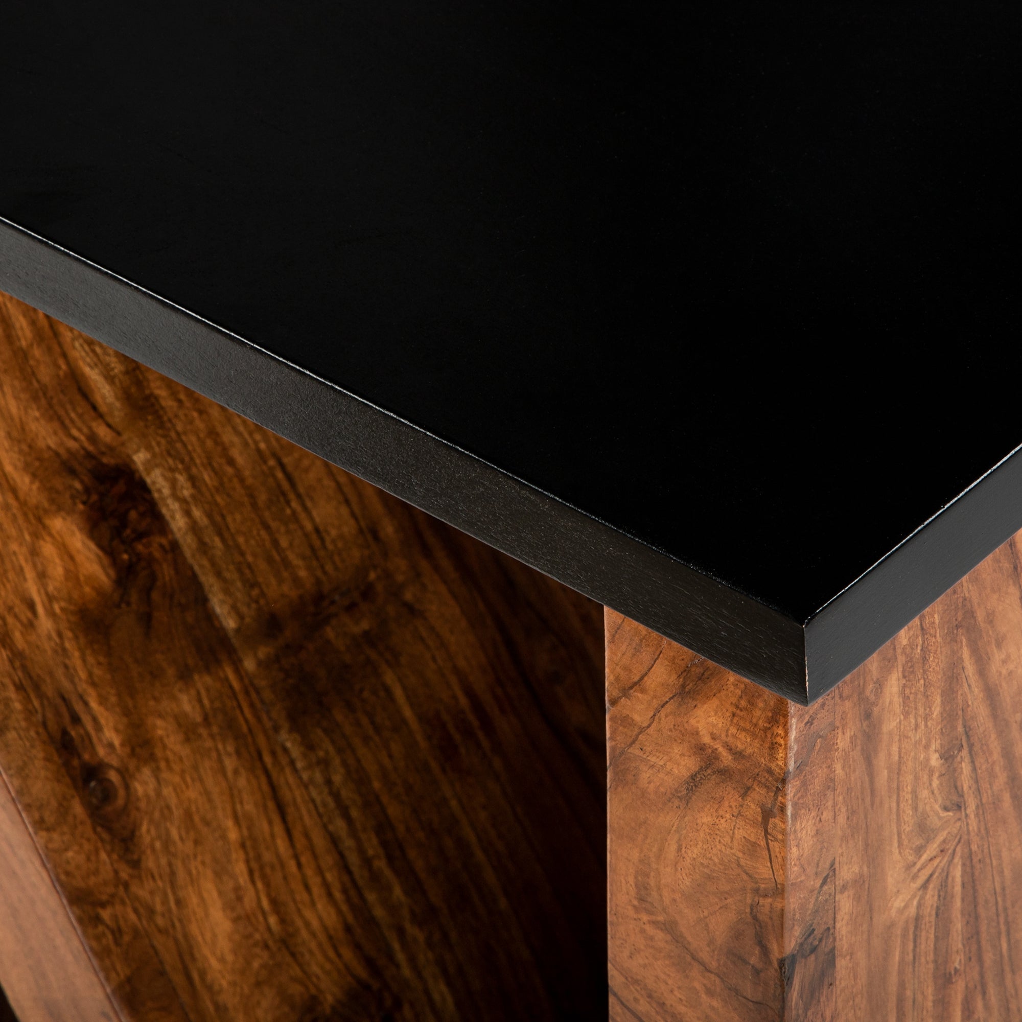 Superficie de mesa de material negro con base de madera.
