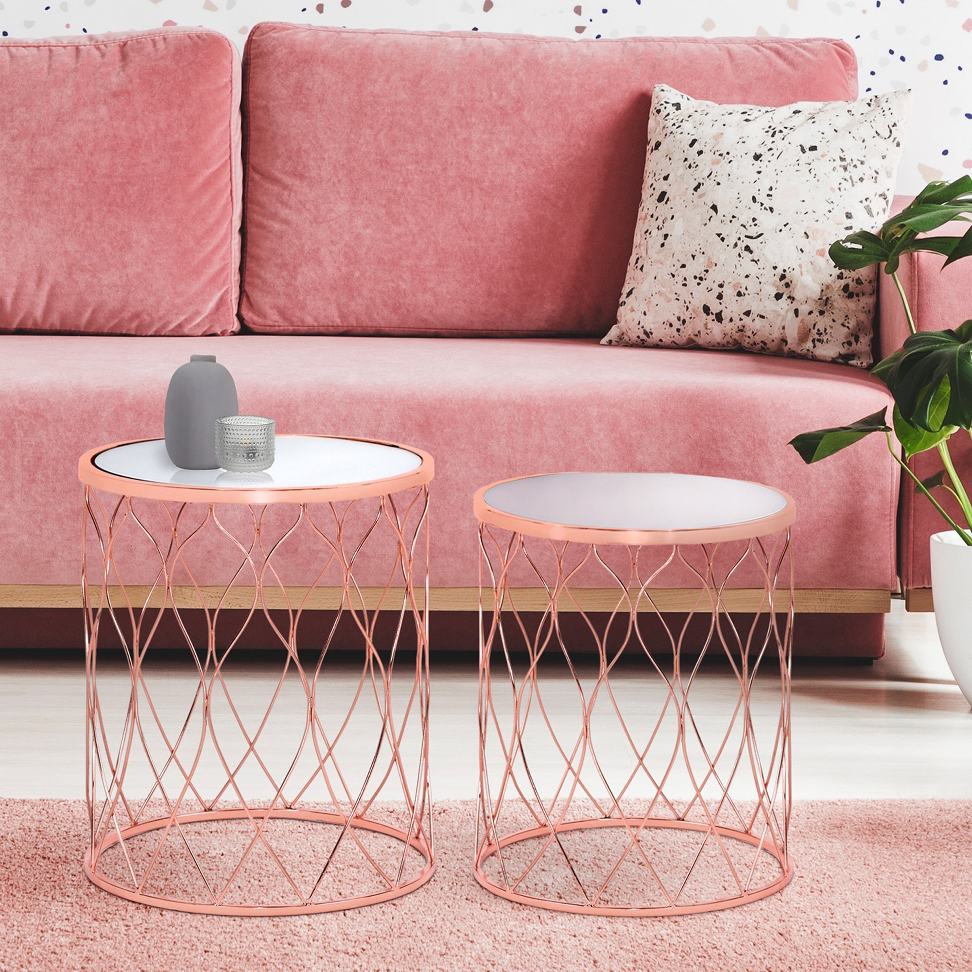Zwei Beistelltische mit runder Tischplatte und Drahtgestell, rosa.