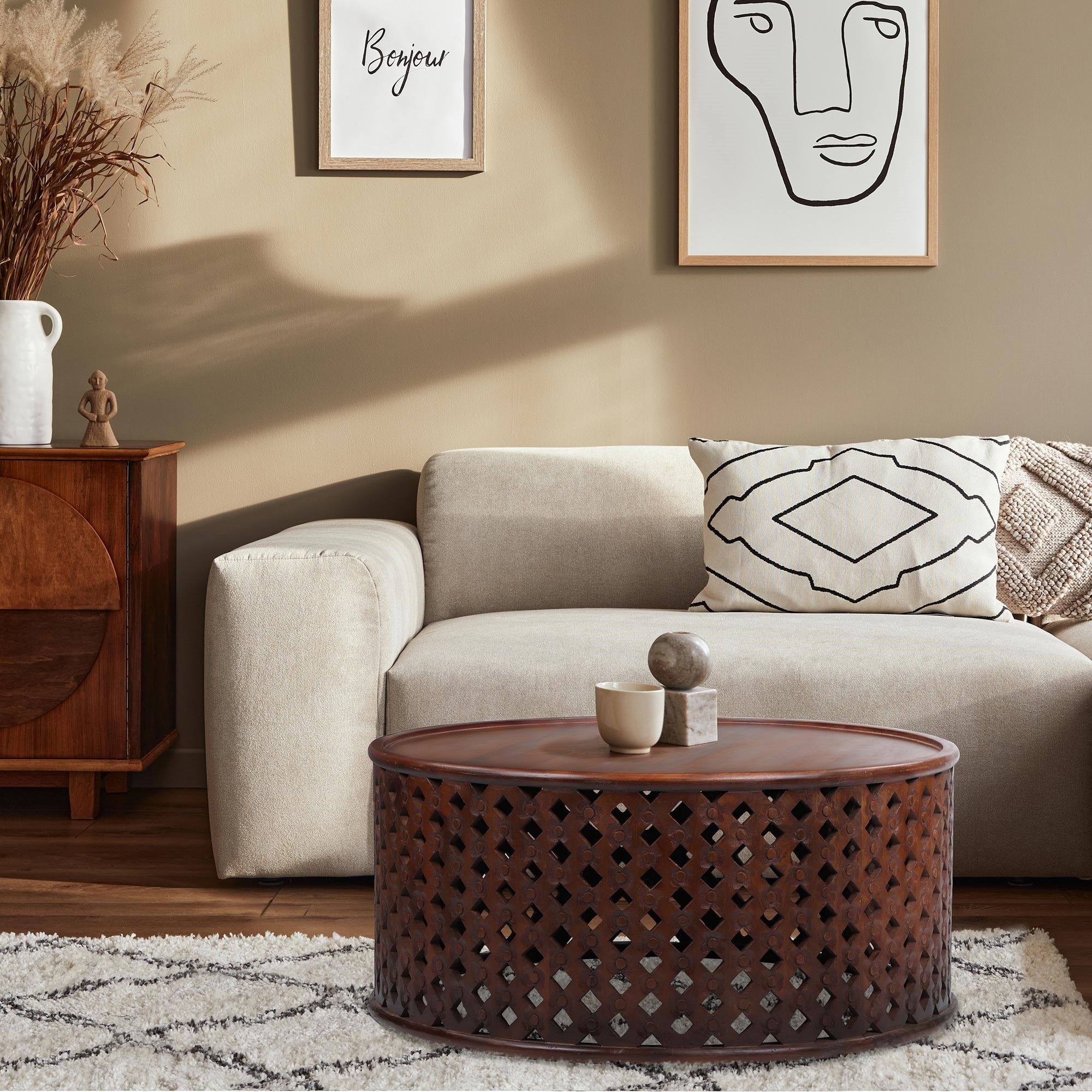 Sala de estar con sofá, mesa de café y cuadros en la pared.