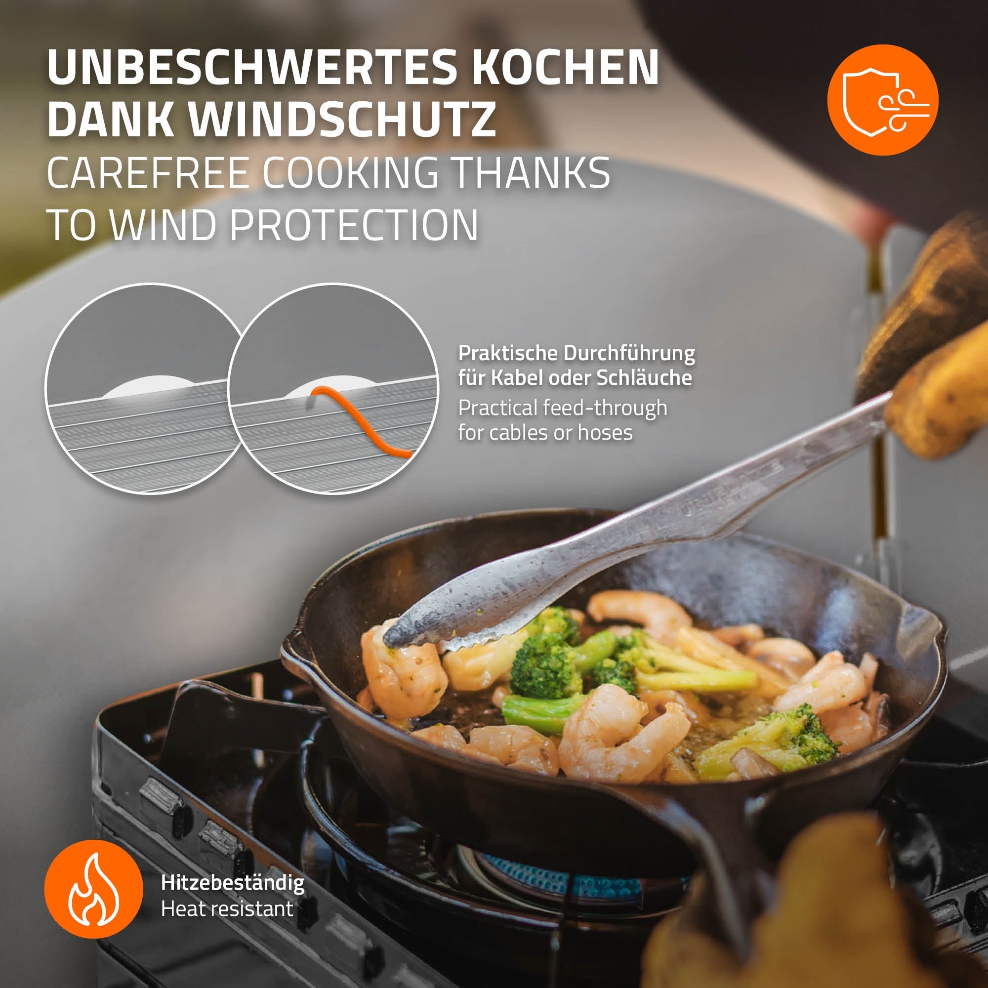 Poêle avec des légumes sur une cuisinière à gaz, pare-vent et passage de câble visibles.