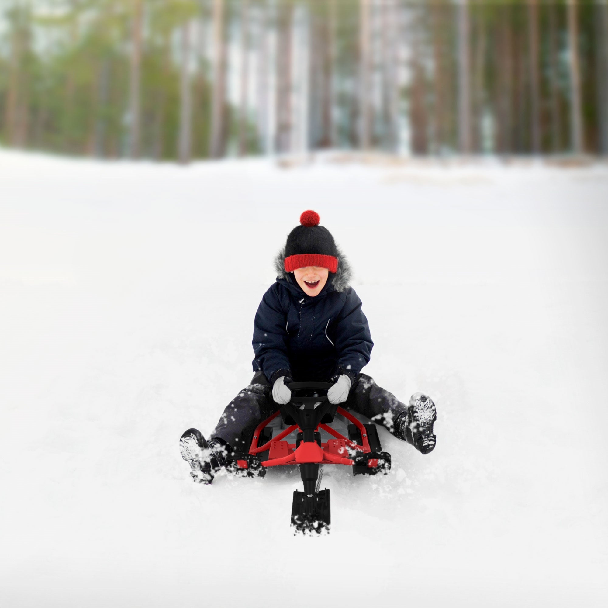 Un enfant riant sur une luge dans la neige, entouré d'arbres.