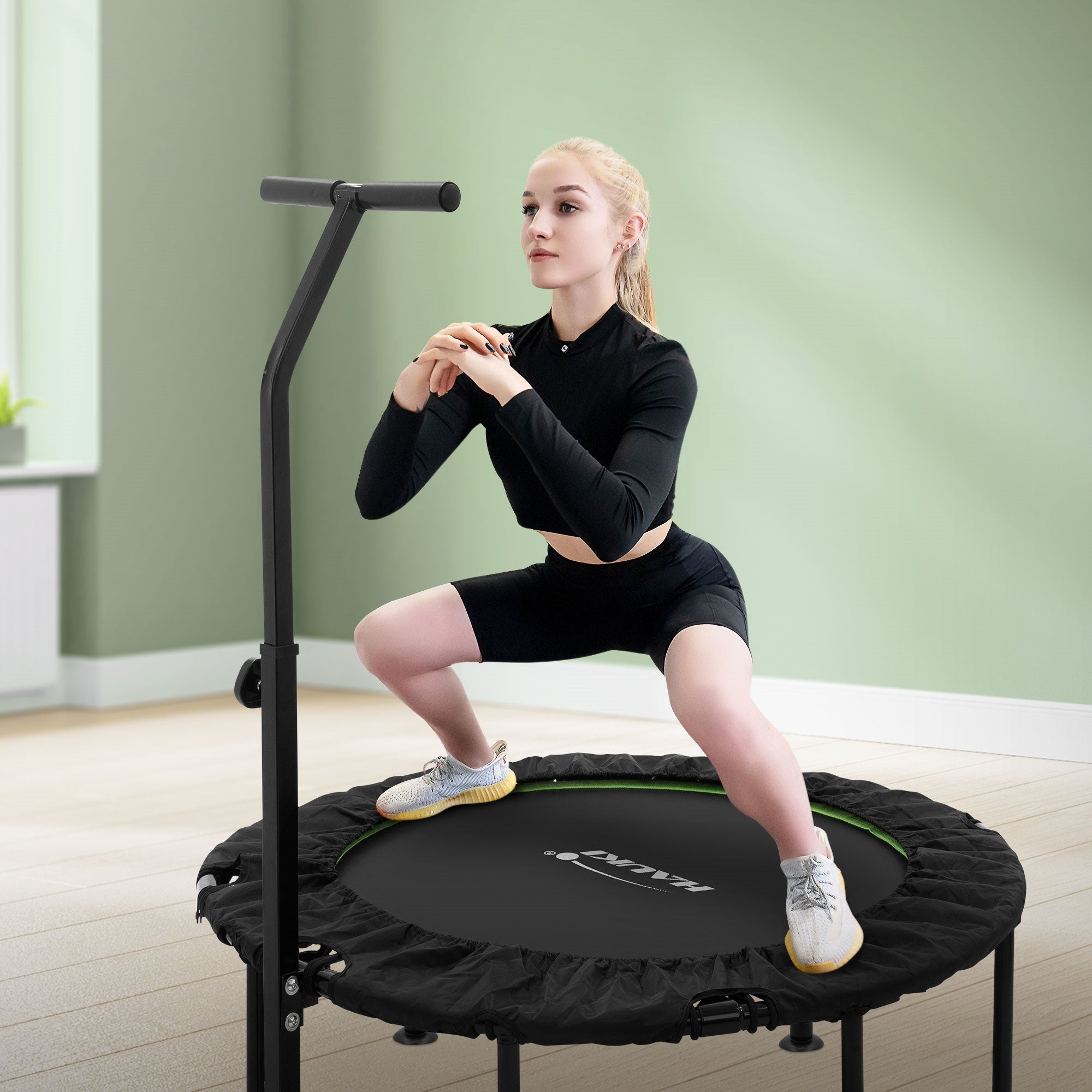 Donna in abbigliamento sportivo fa squat su un trampolino.