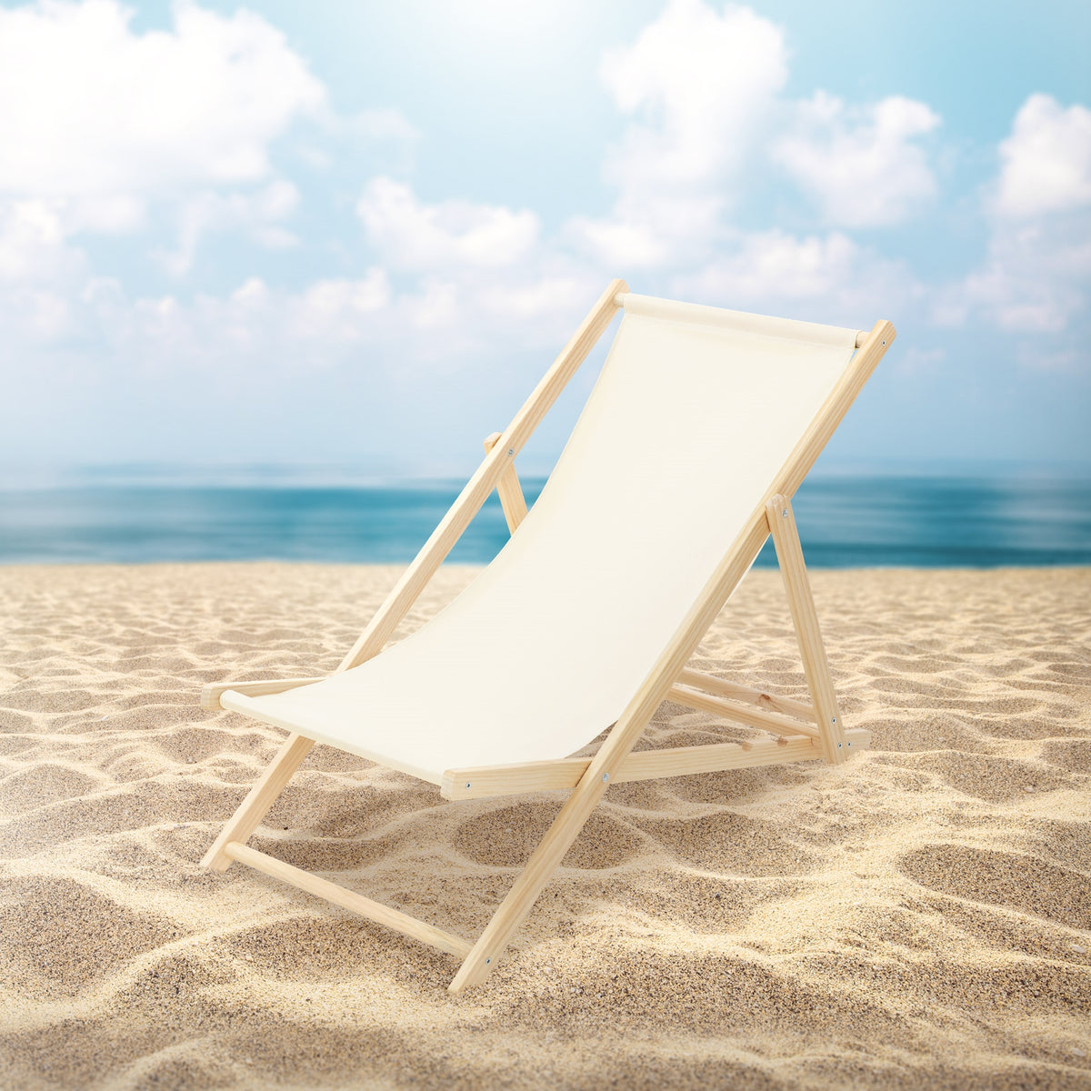 Una sedia a sdraio in legno si trova sulla spiaggia davanti a un cielo blu.