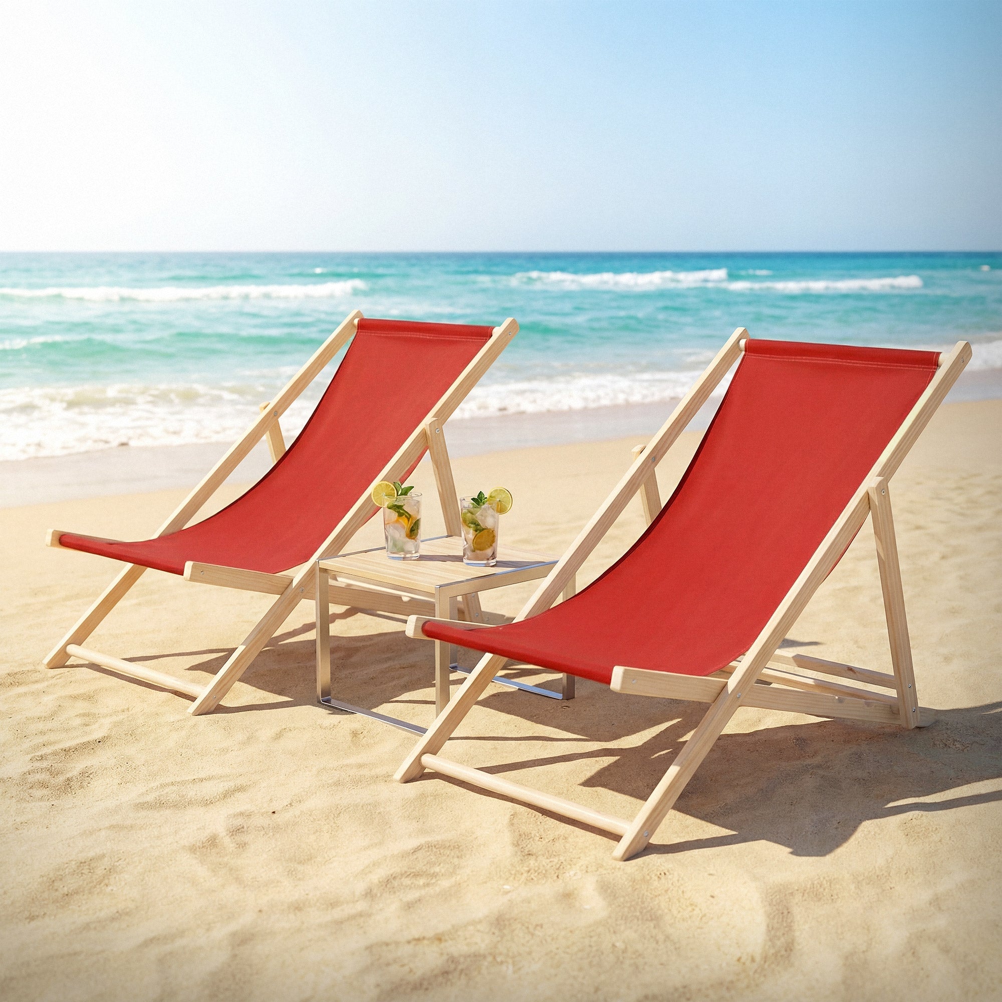 Two deck chairs on the beach with red upholstery and a small table.