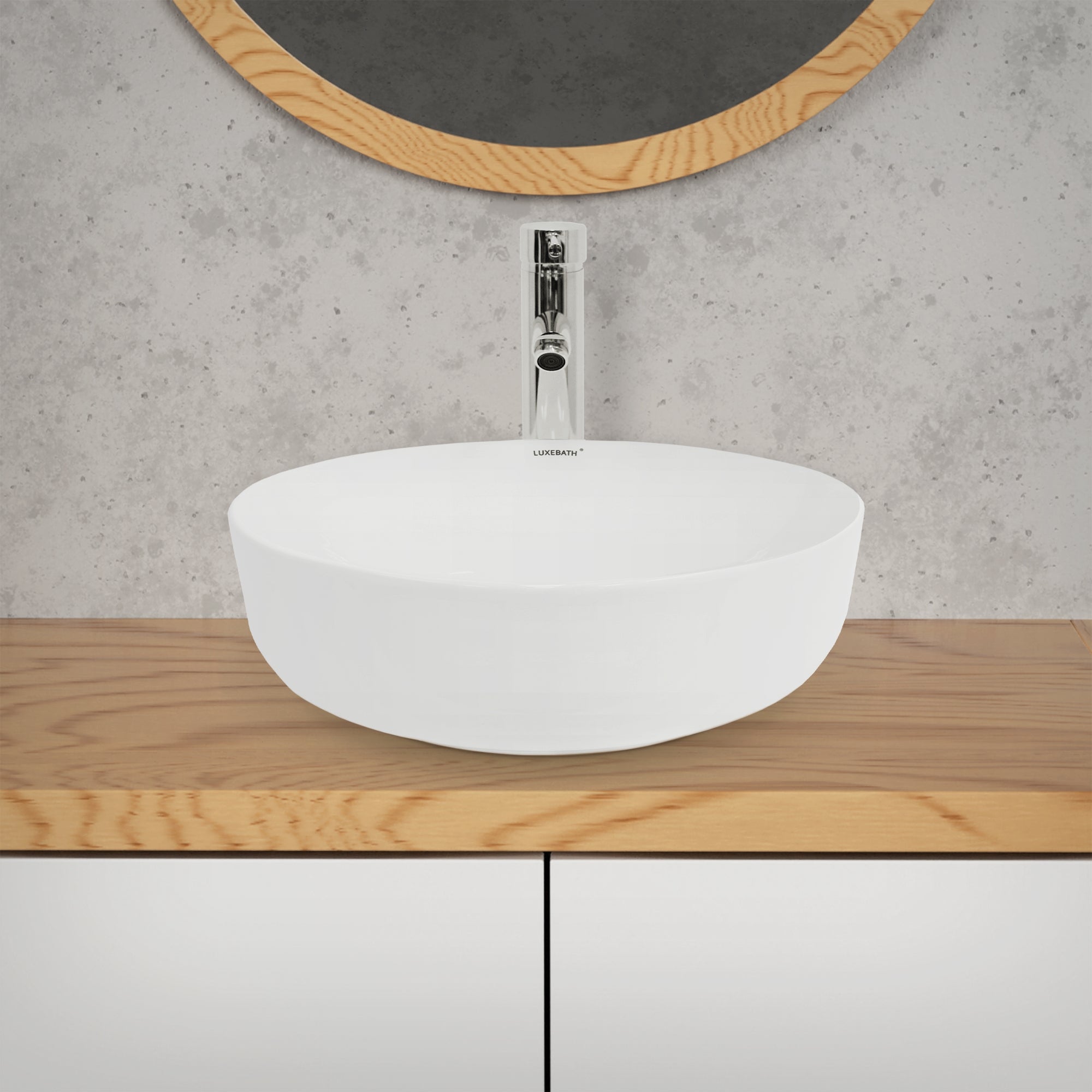 Lavabo bianco e rotondo su un mobile in legno con specchio sullo sfondo.