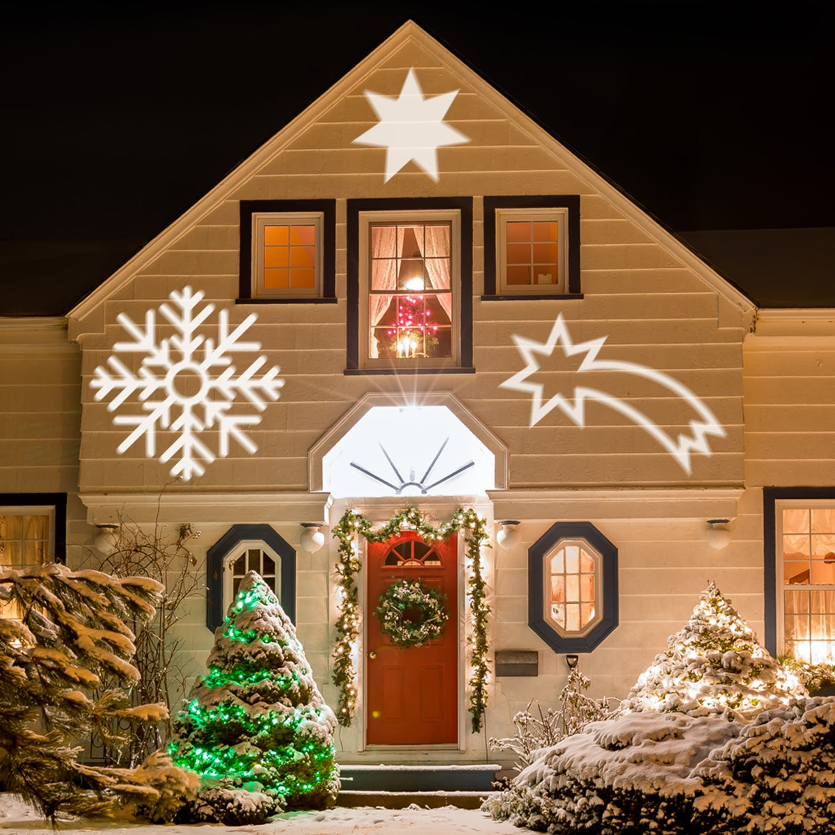 Haus mit Weihnachtslichtern und Projektionen von Sternen und Schneeflocken.