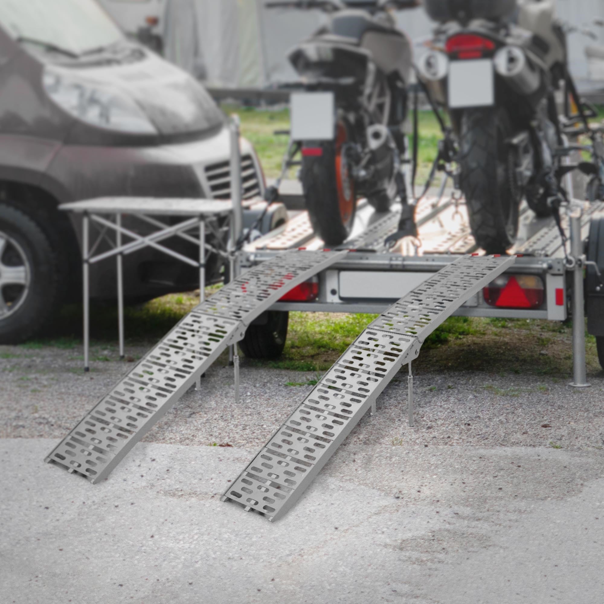 Deux motos sur une remorque avec deux rampes au premier plan.