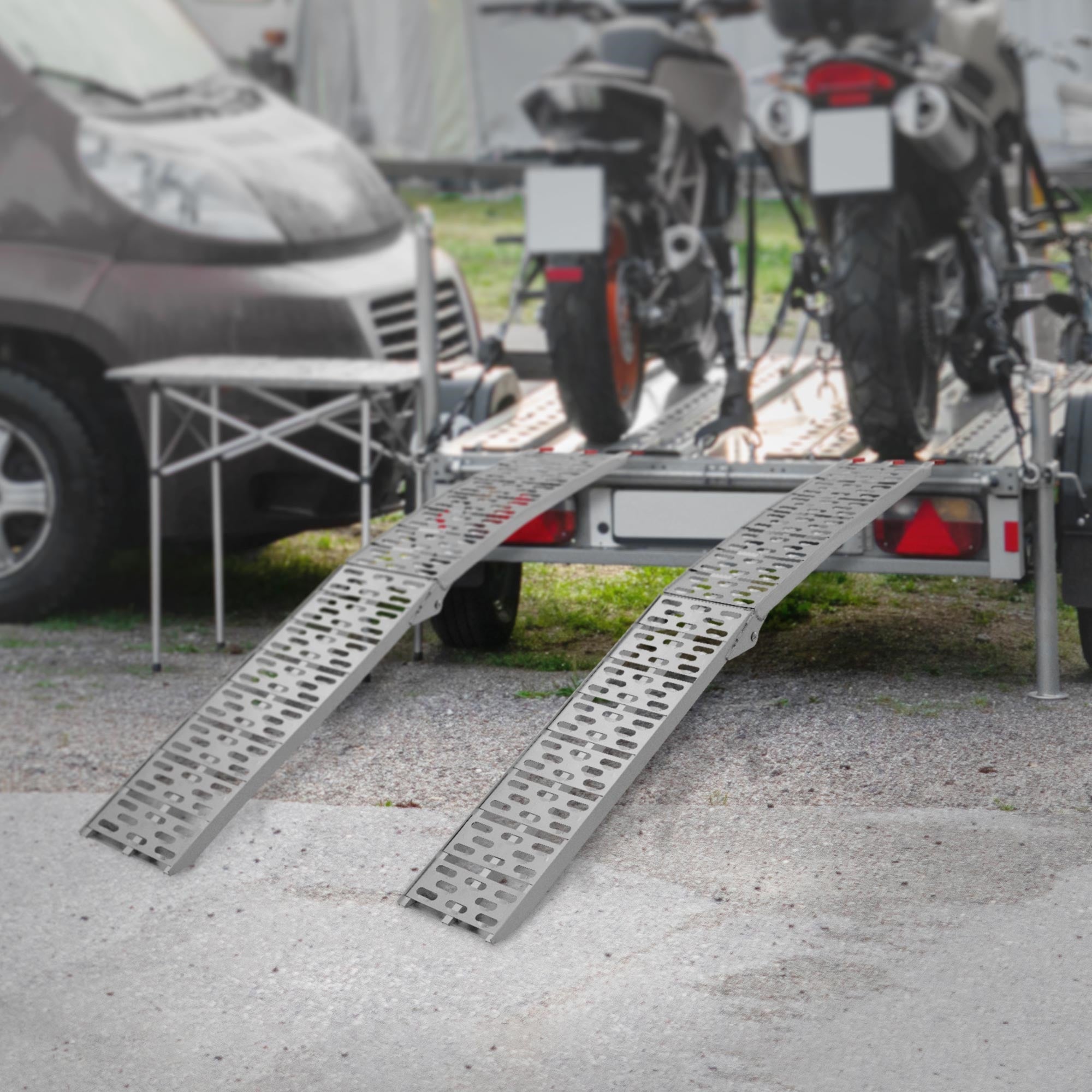 Zwei Motorräder auf einem Anhänger mit zwei Rampen.
