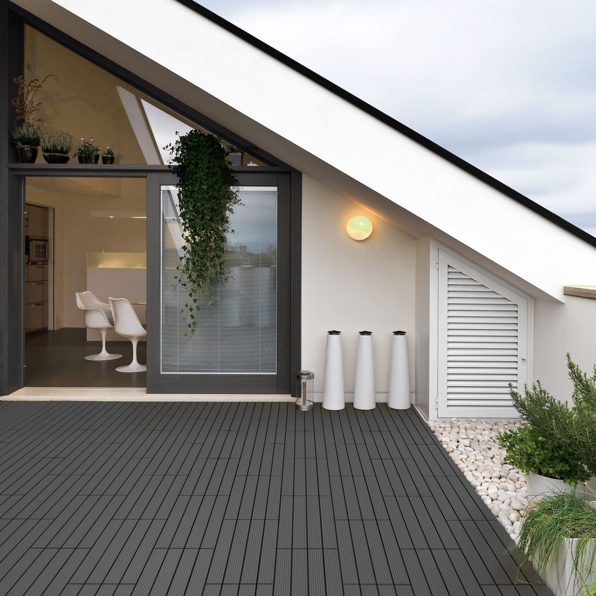 Modern terrace with WPC tiles, plants, and furniture in the background.