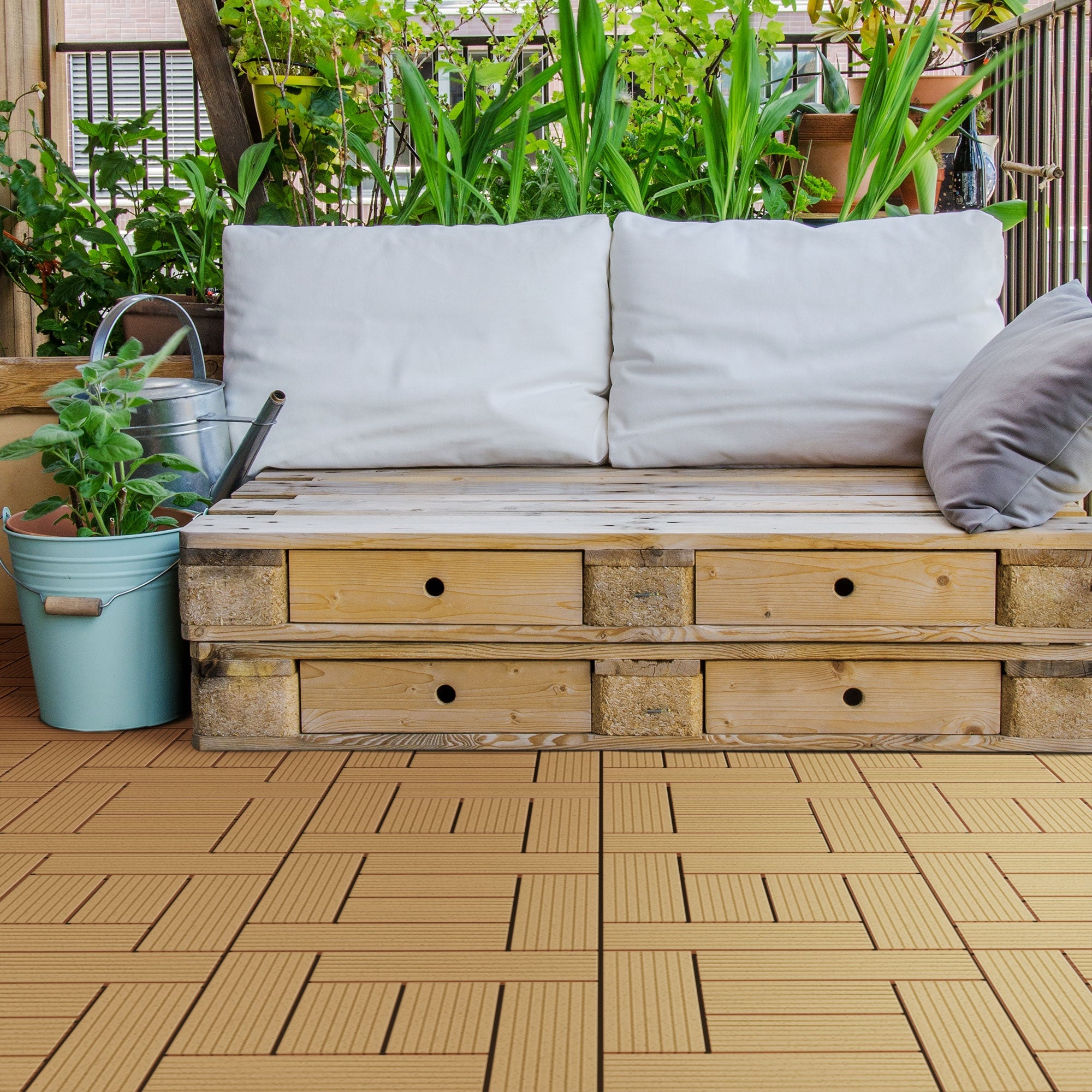 Gemütliche Sitzecke mit Holzbank, Kissen und Pflanzen im Hintergrund.
