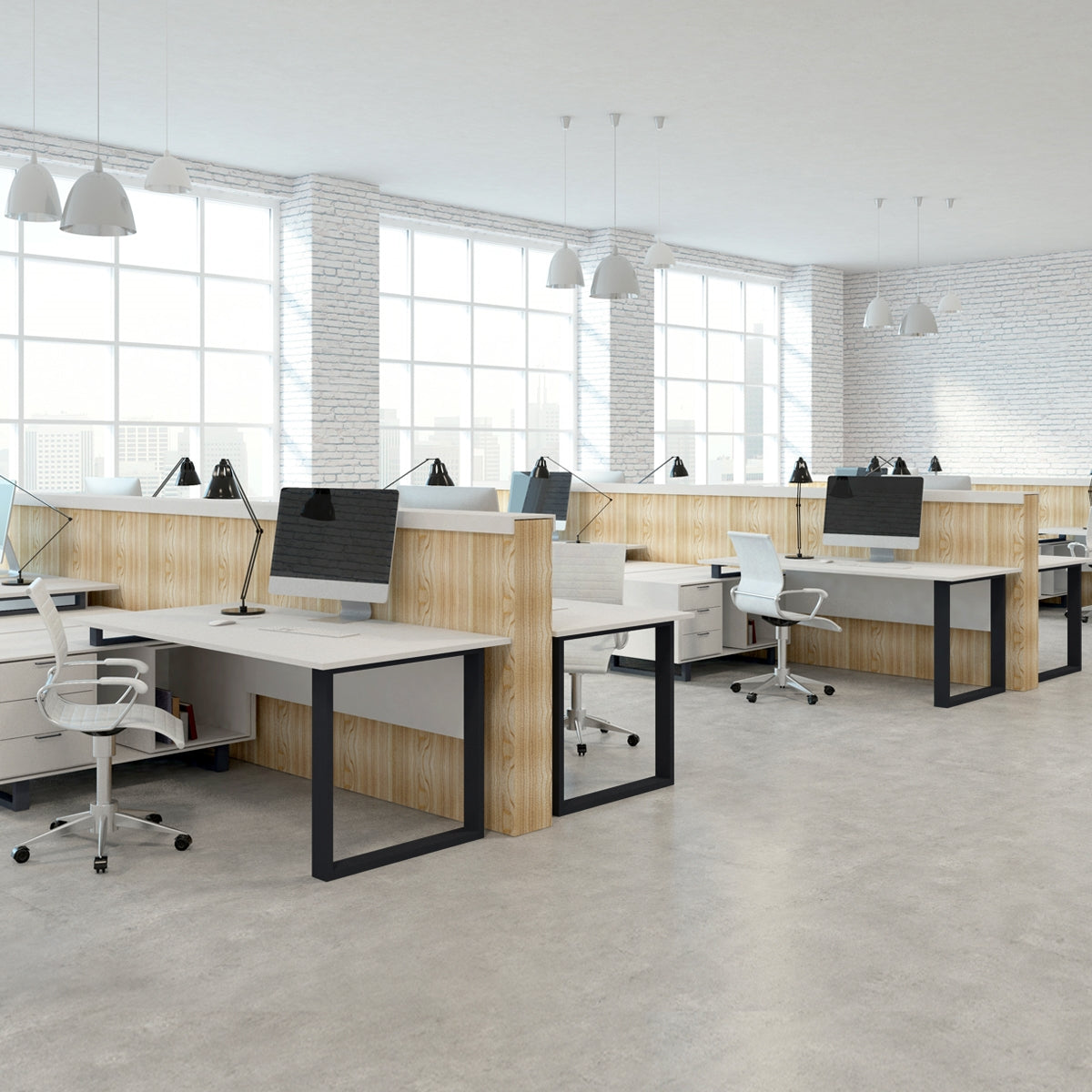 Bureau avec plusieurs postes de travail, tables et moniteurs dans une pièce lumineuse.