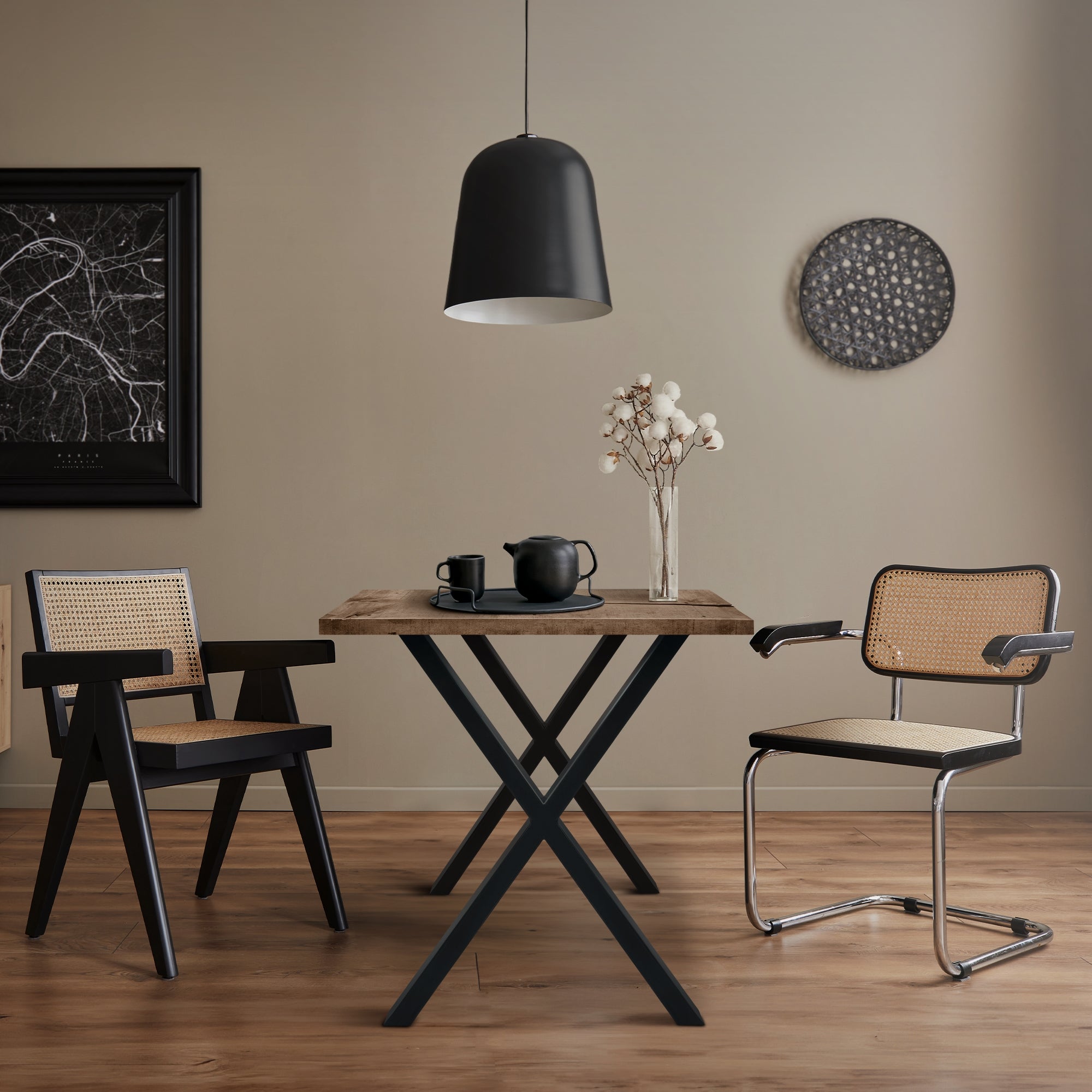 Ein Tisch mit zwei Stühlen in einem modernen Raum, mit einer Lampe und Wanddekoration.