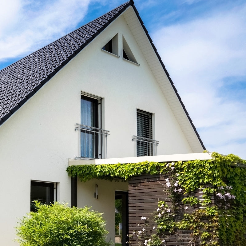 Ein modernes Haus mit einem begrünten Eingangsbereich und einem Vordach.