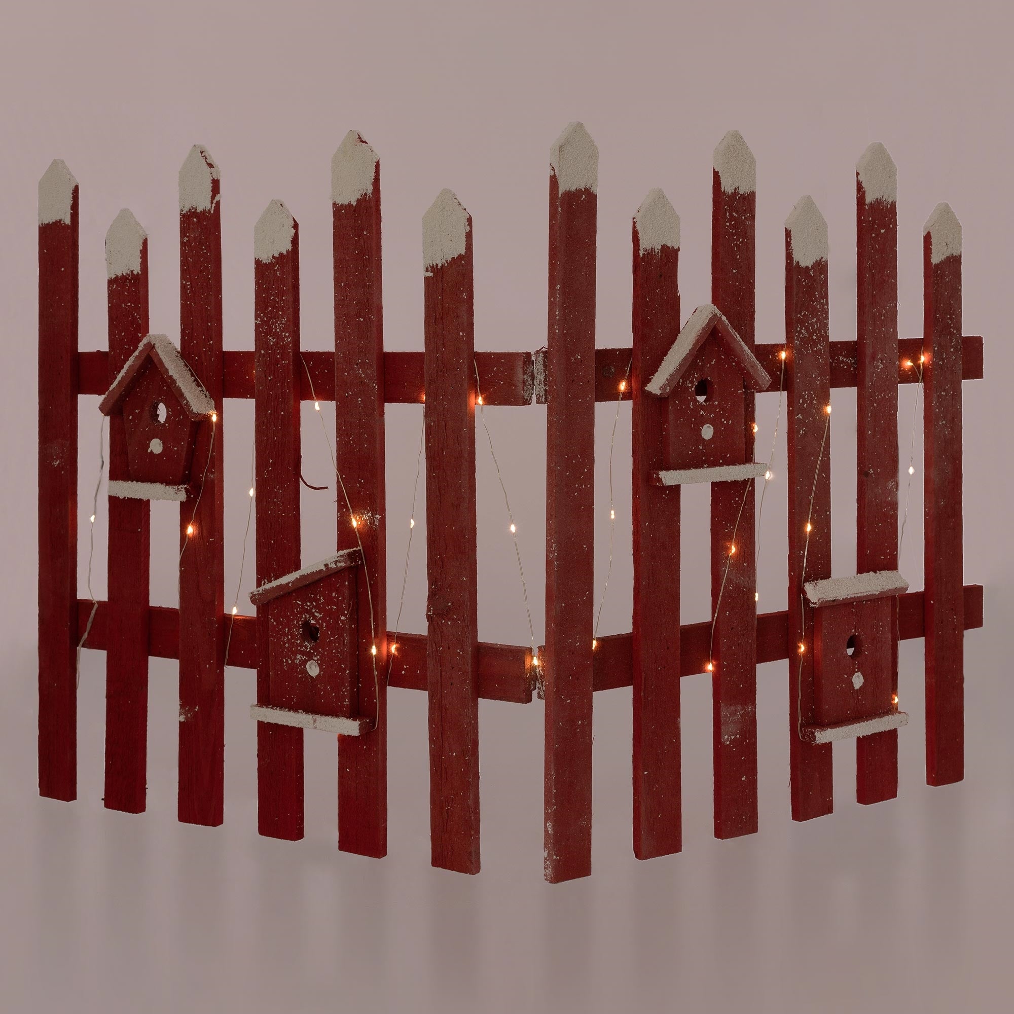 Holzzaun in Rot mit Vogelhäusern und Lichtern, auf einem einfarbigen Hintergrund.