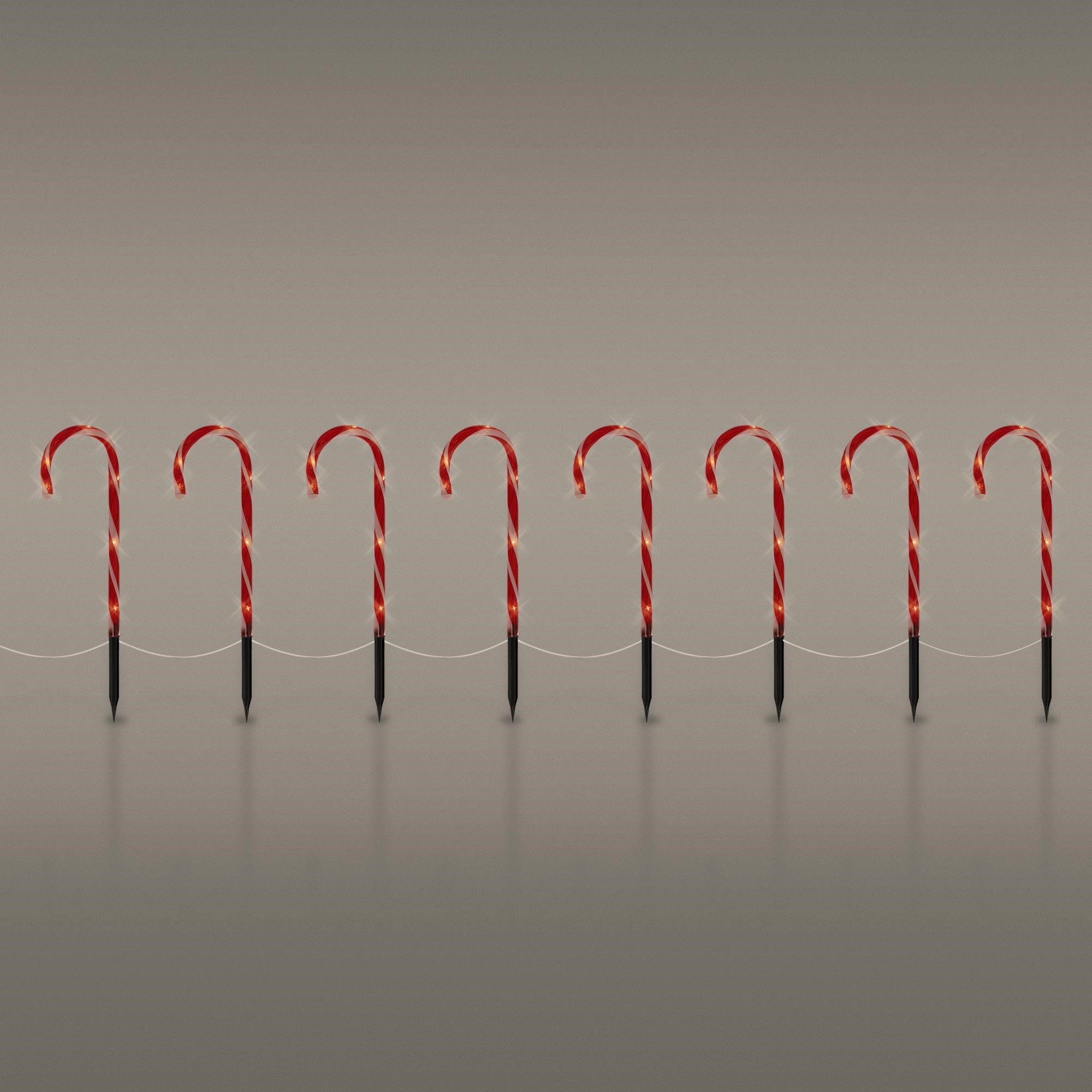 Zehn rote und weiße Zuckerstangen auf einem grauen Hintergrund.