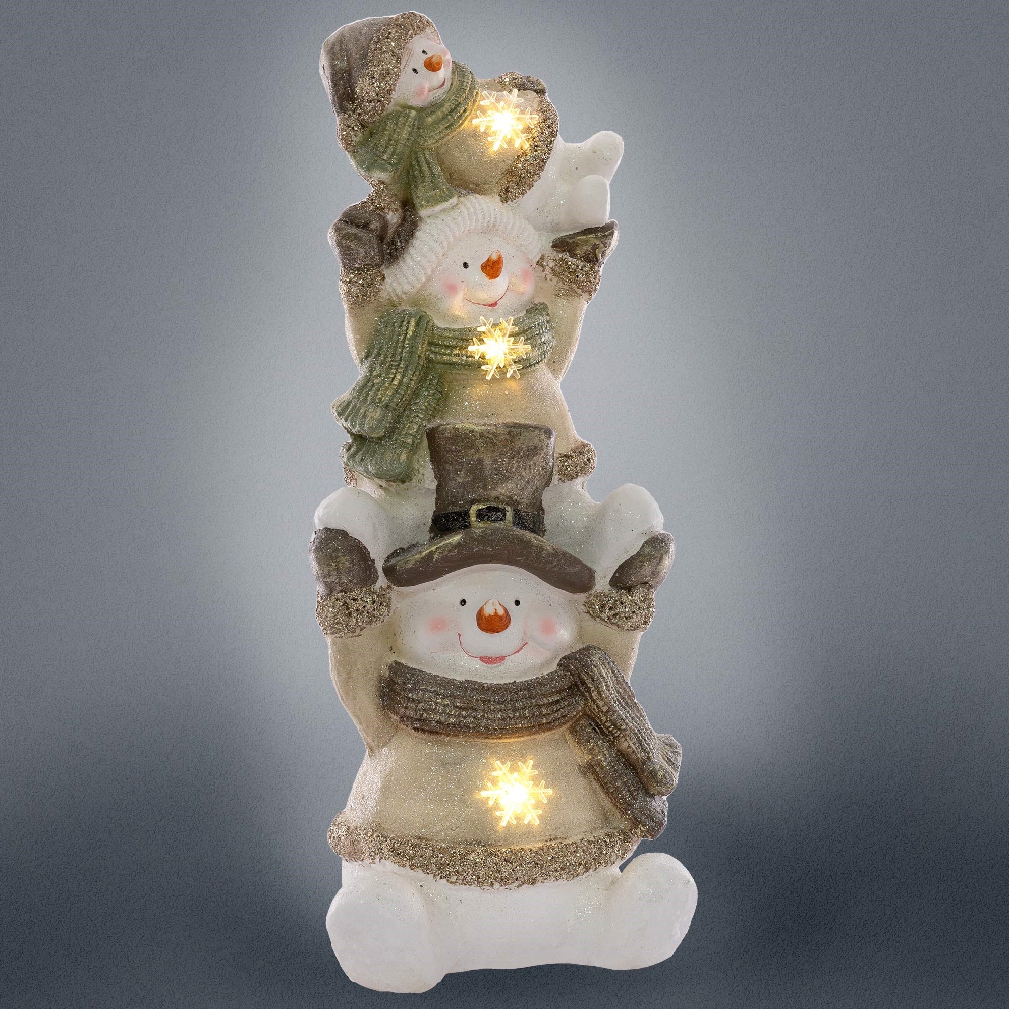 Tres muñecos de nieve, uno con sombrero, que están iluminados.