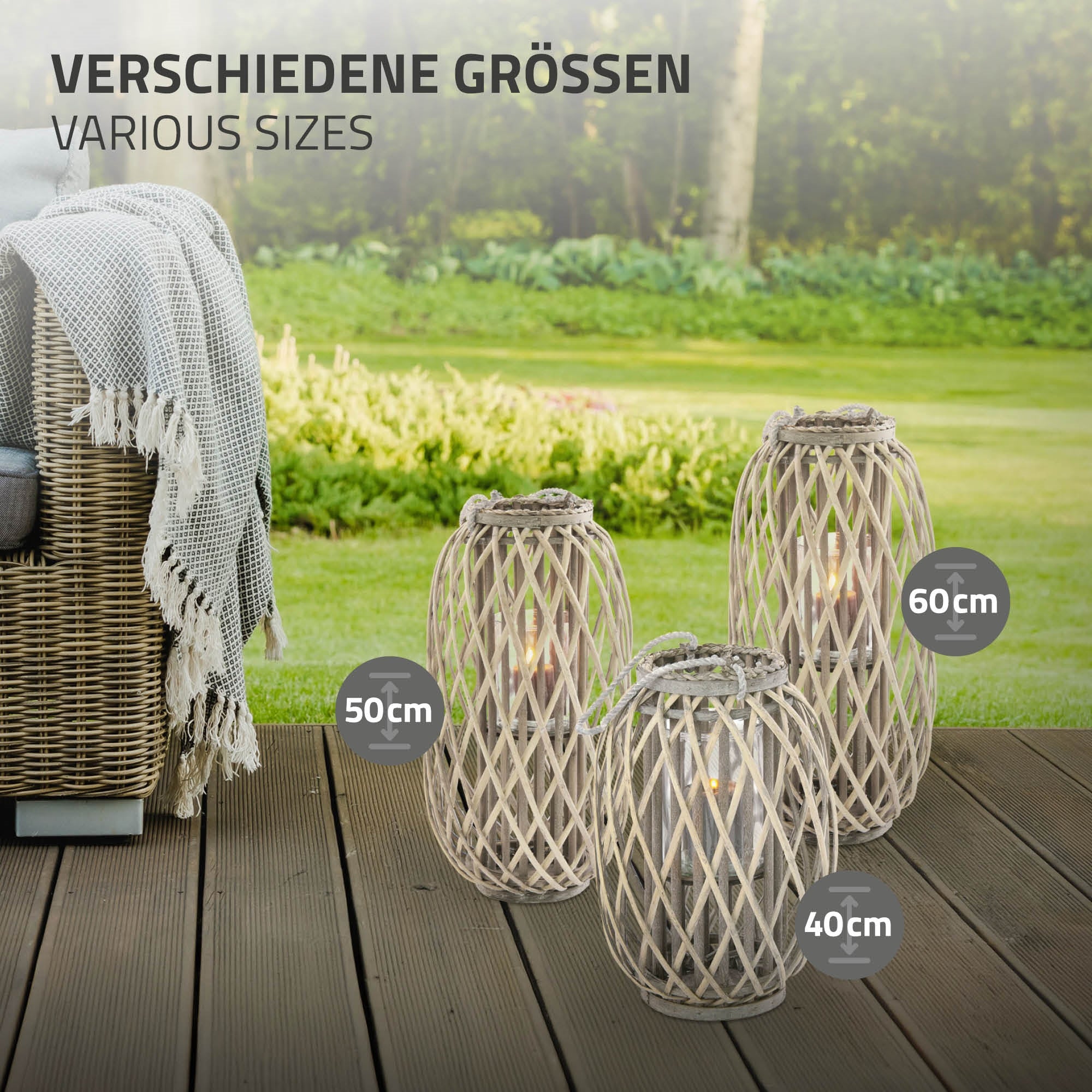 Vier Laternen in verschiedenen Größen auf einem Holzboden, mit Garten im Hintergrund.