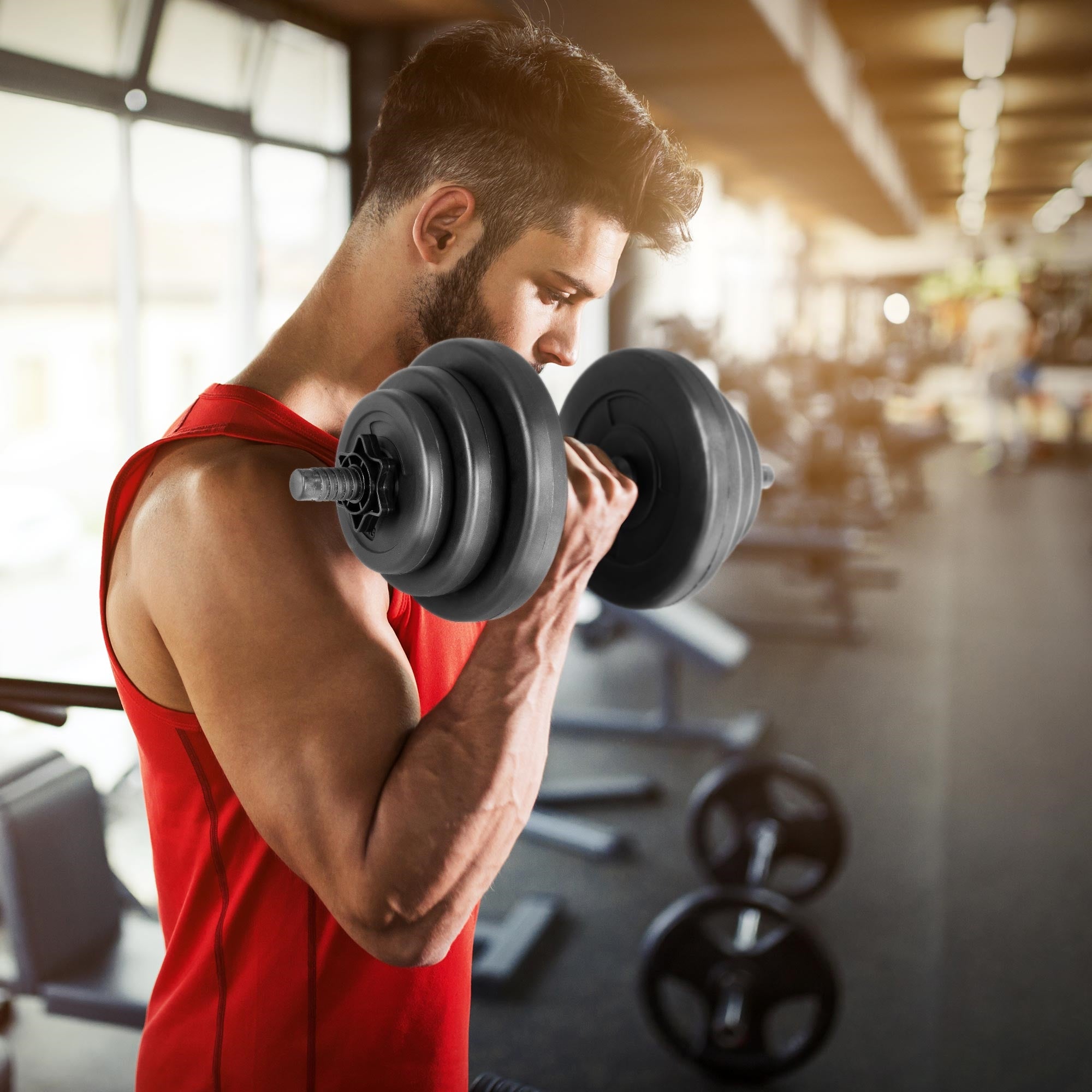 Muž s činkou v posilovně, trénuje biceps.