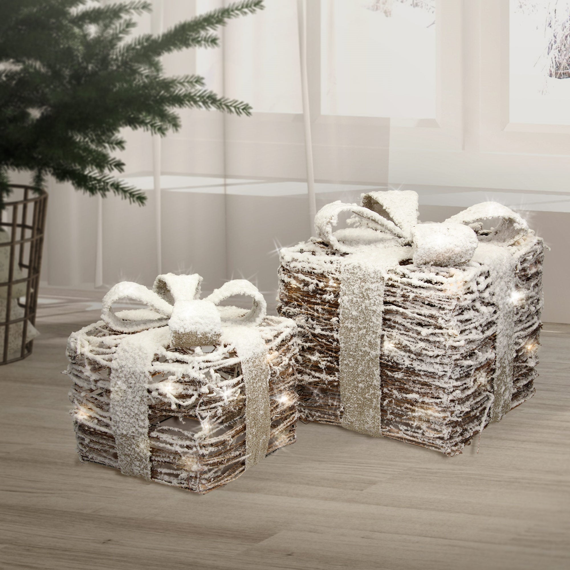 Zwei Geschenkpäckchen mit Schleifen, dekoriert mit Schnee, auf einem Boden.