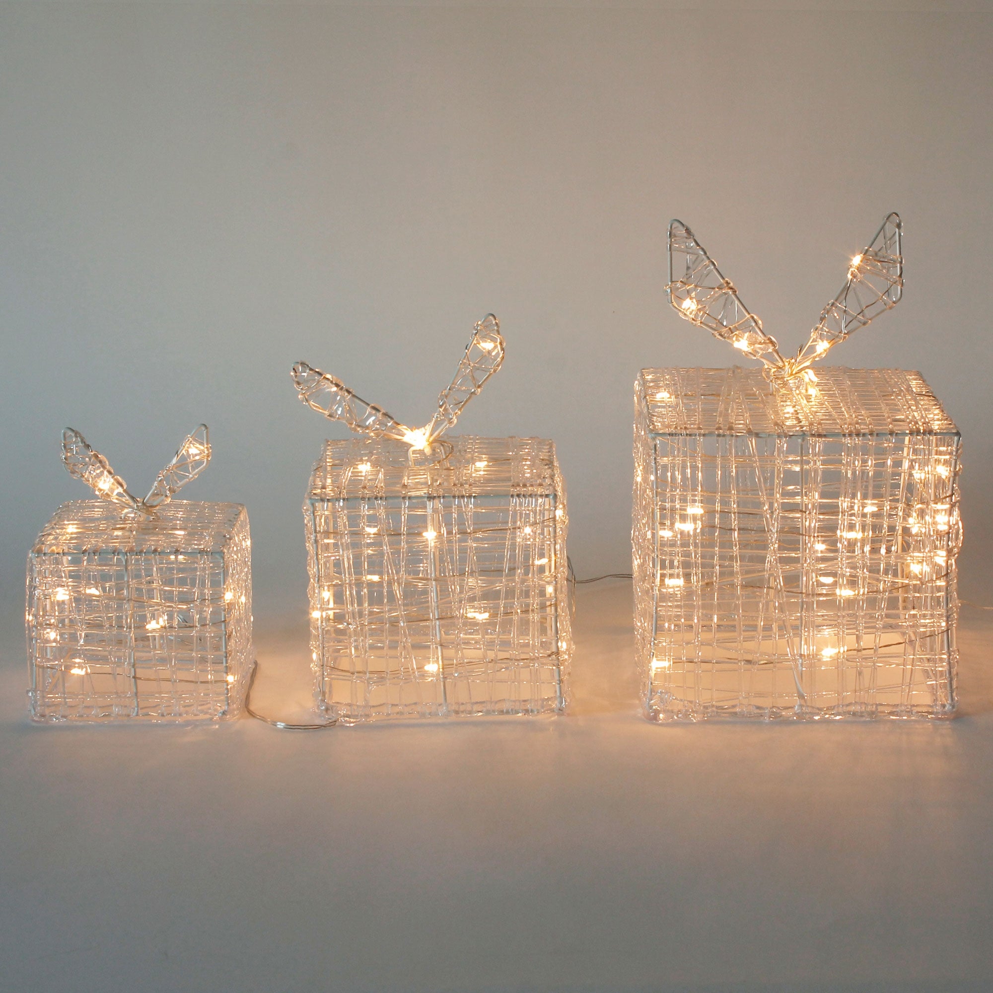 Tres regalos brillantes con alambre y alas.