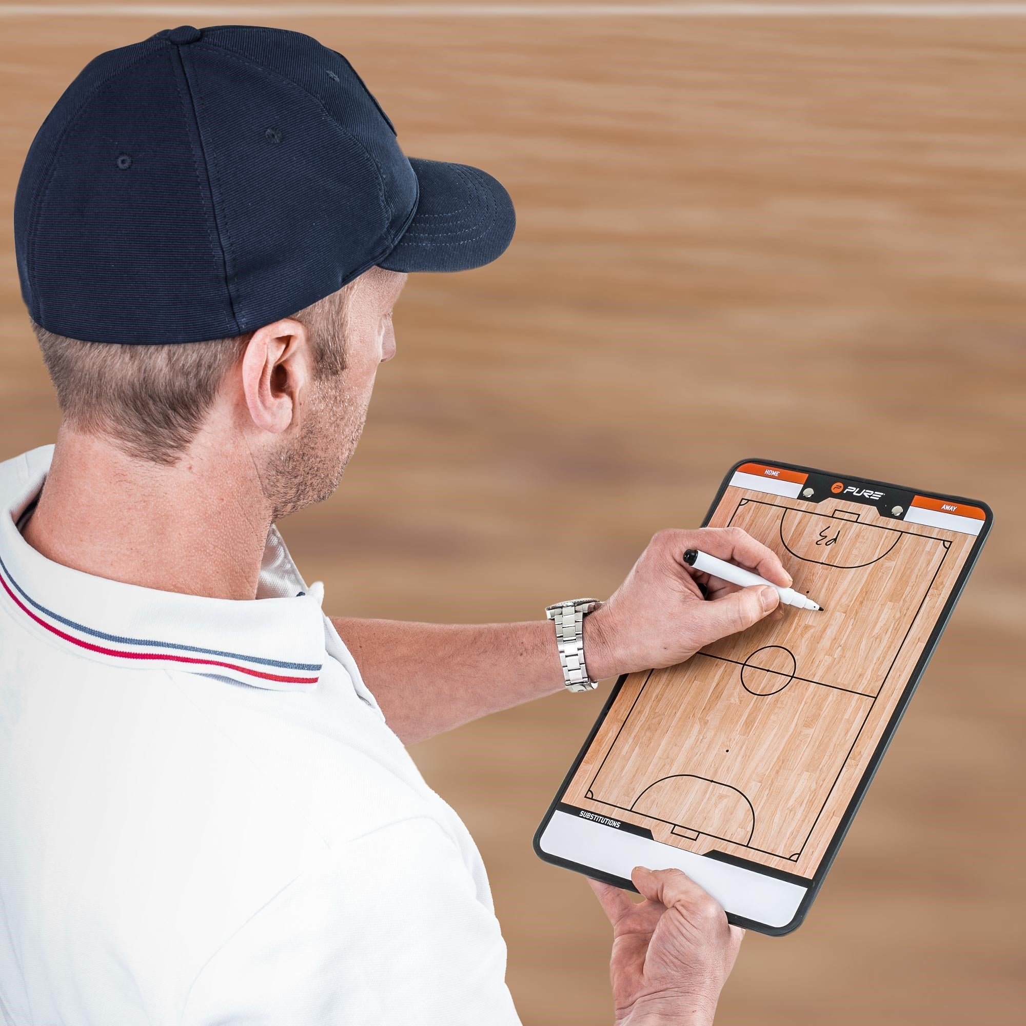 Ein Trainer schreibt auf einem Basketball-Taktikboard mit einem Stift.