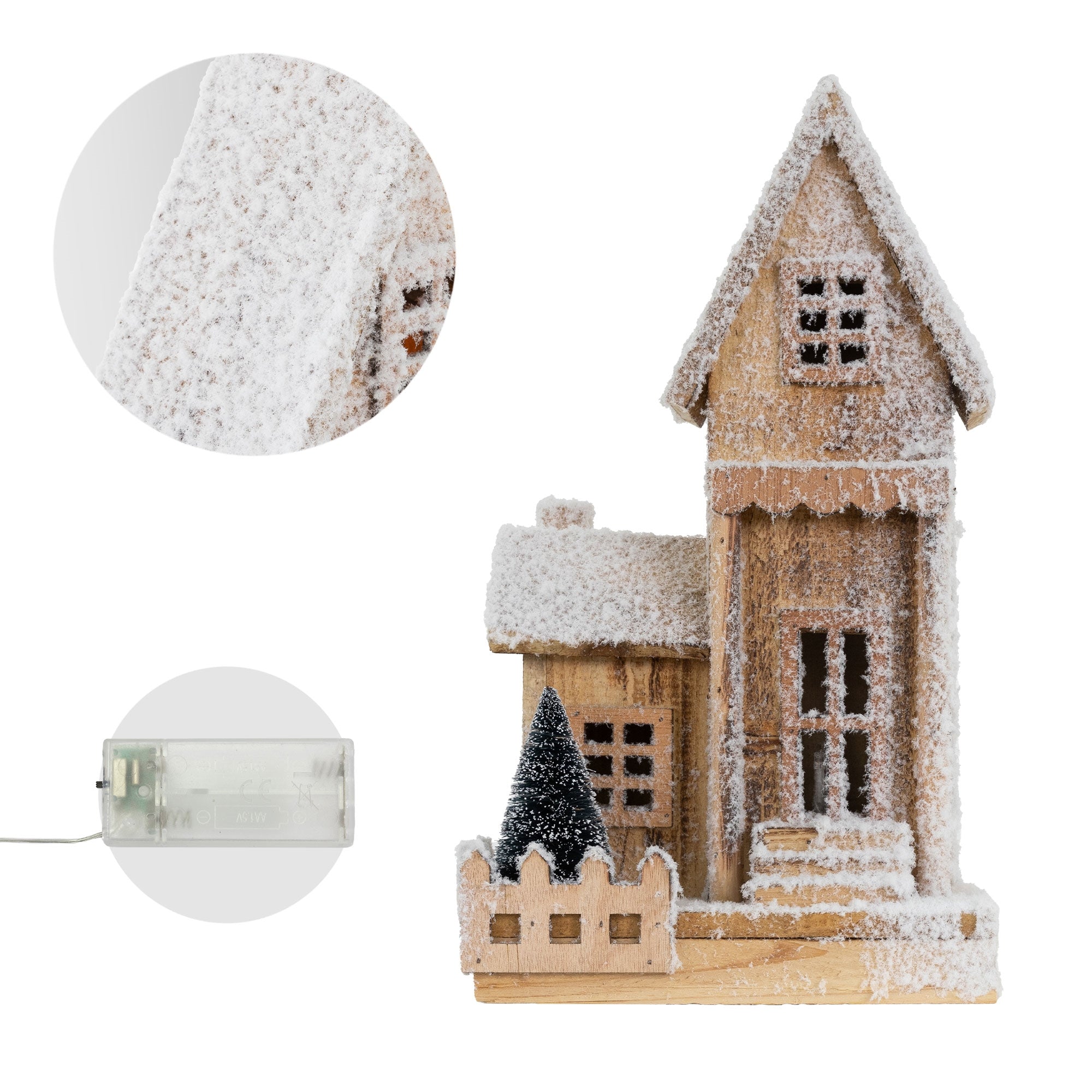 Detaljevisning af et træhus med sne og et lille juletræ.