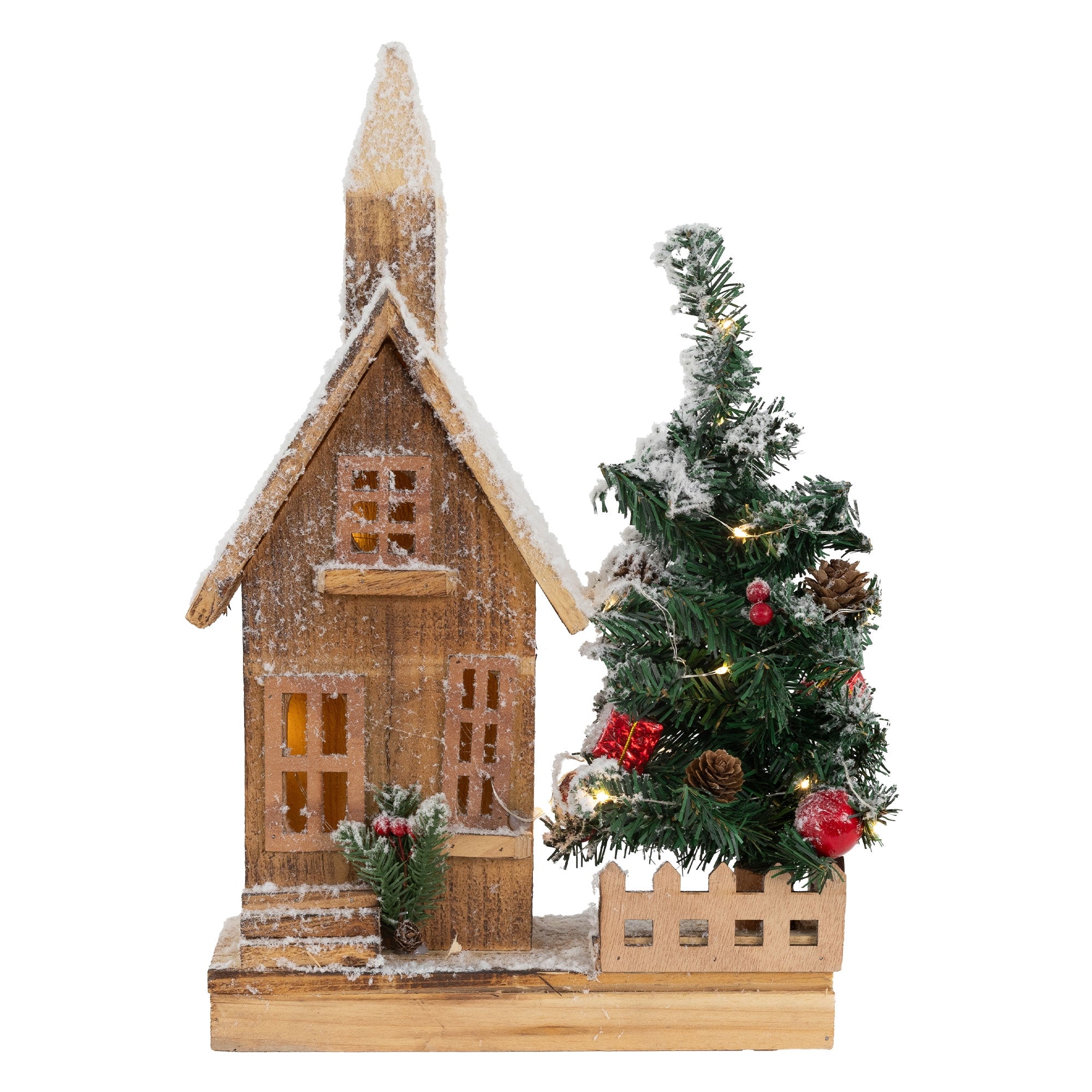 Side view of a wooden house with snow and a small Christmas tree.