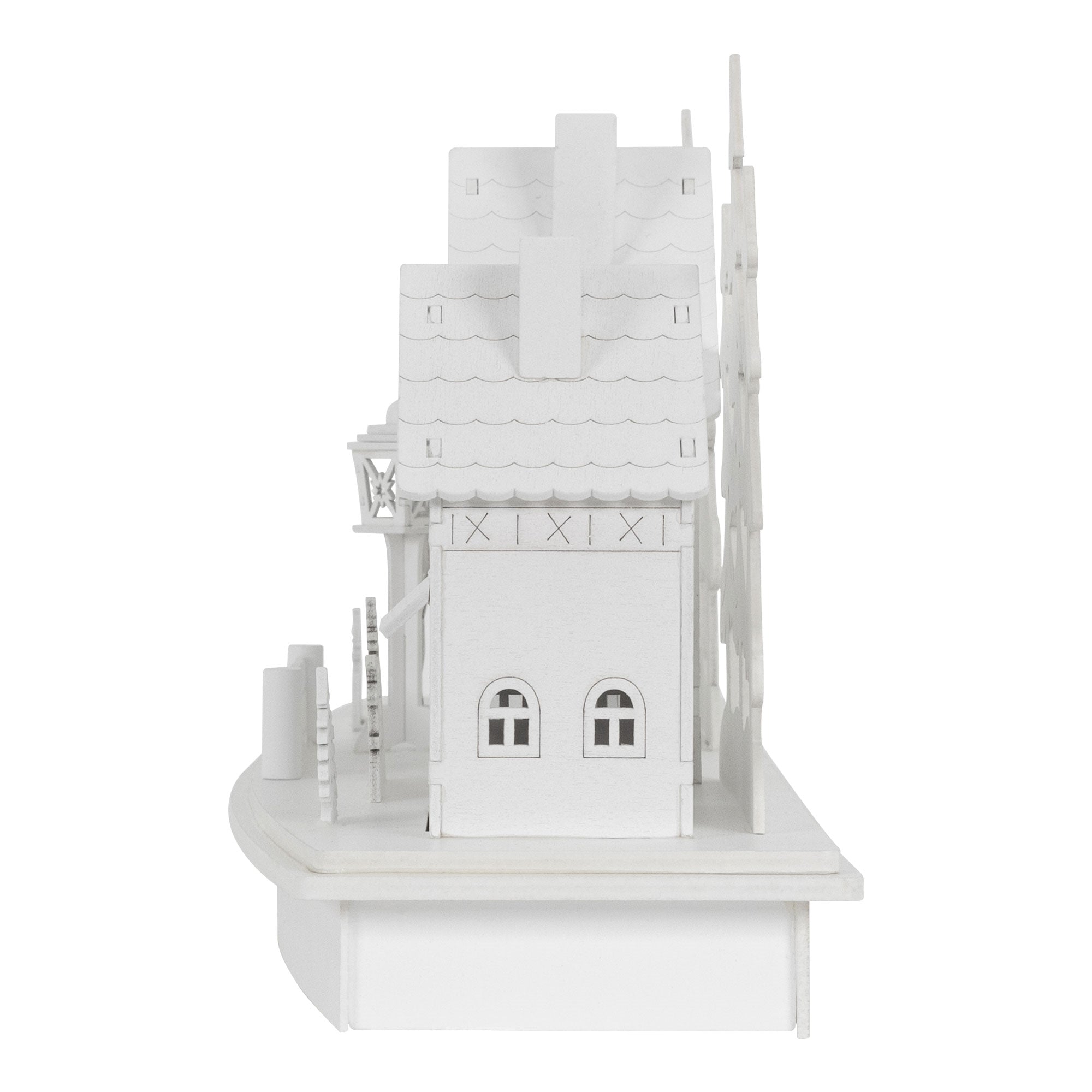 Vue de côté d'une maison blanche avec des fenêtres et des arbres.