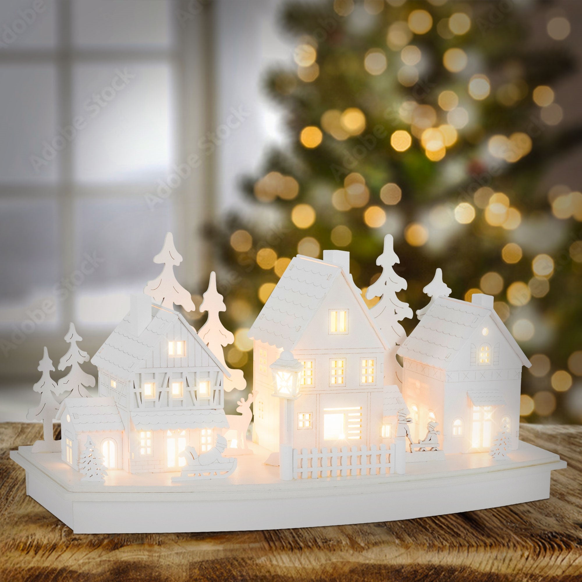 Maisons blanches avec une lumière chaude, entourées de lumières floues en arrière-plan.