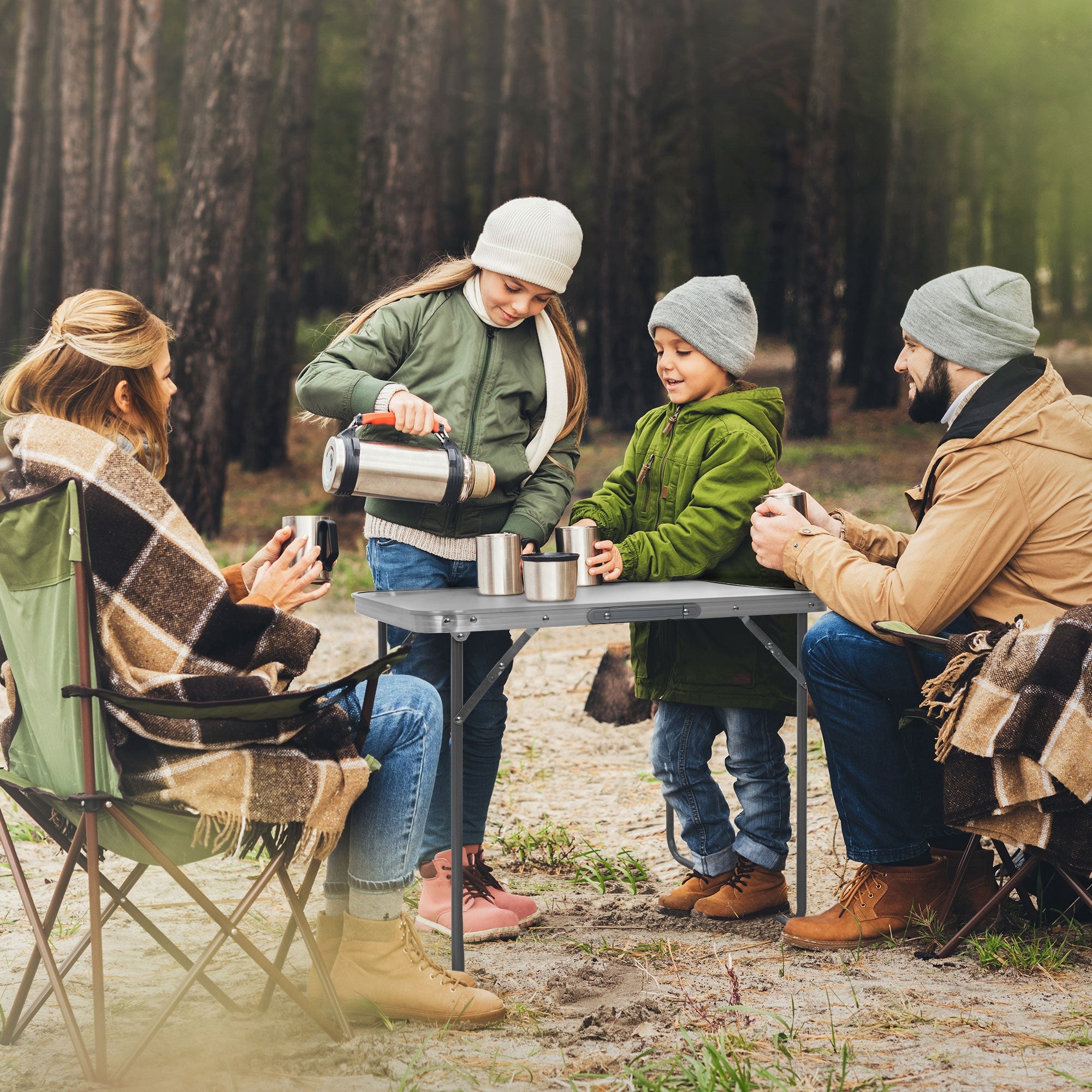 Familia sentada a la mesa en el bosque, un niño sirviendo bebidas.
