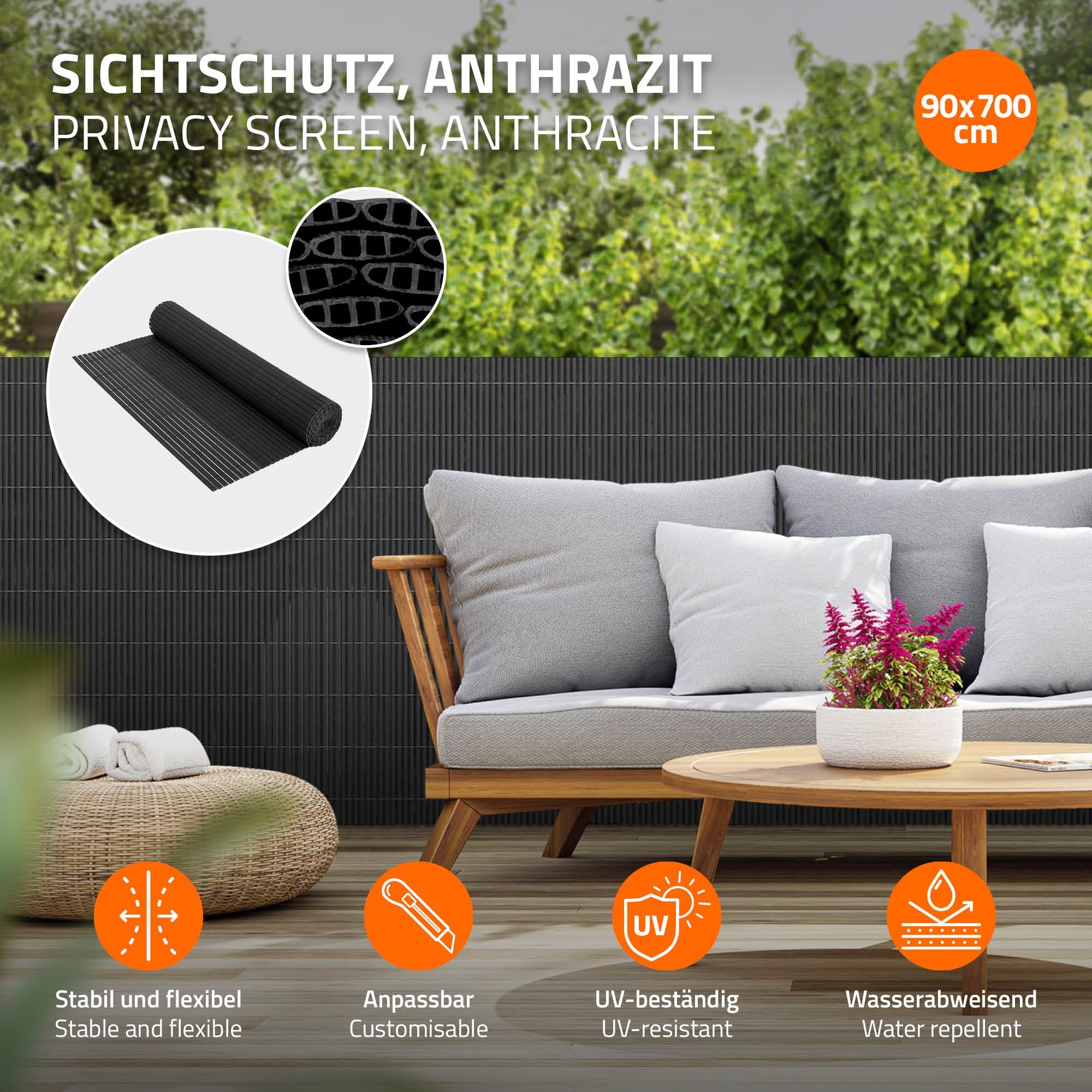Ein Sichtschutz in Anthrazit mit Sofa und Pflanzen im Hintergrund.