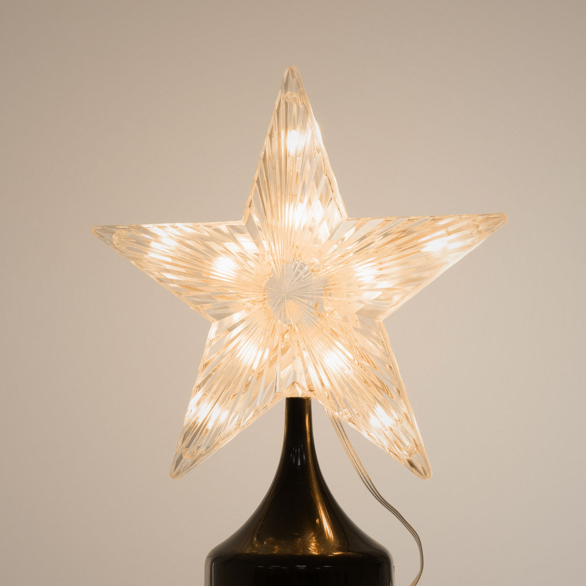 Transparent illuminated star on a black base.