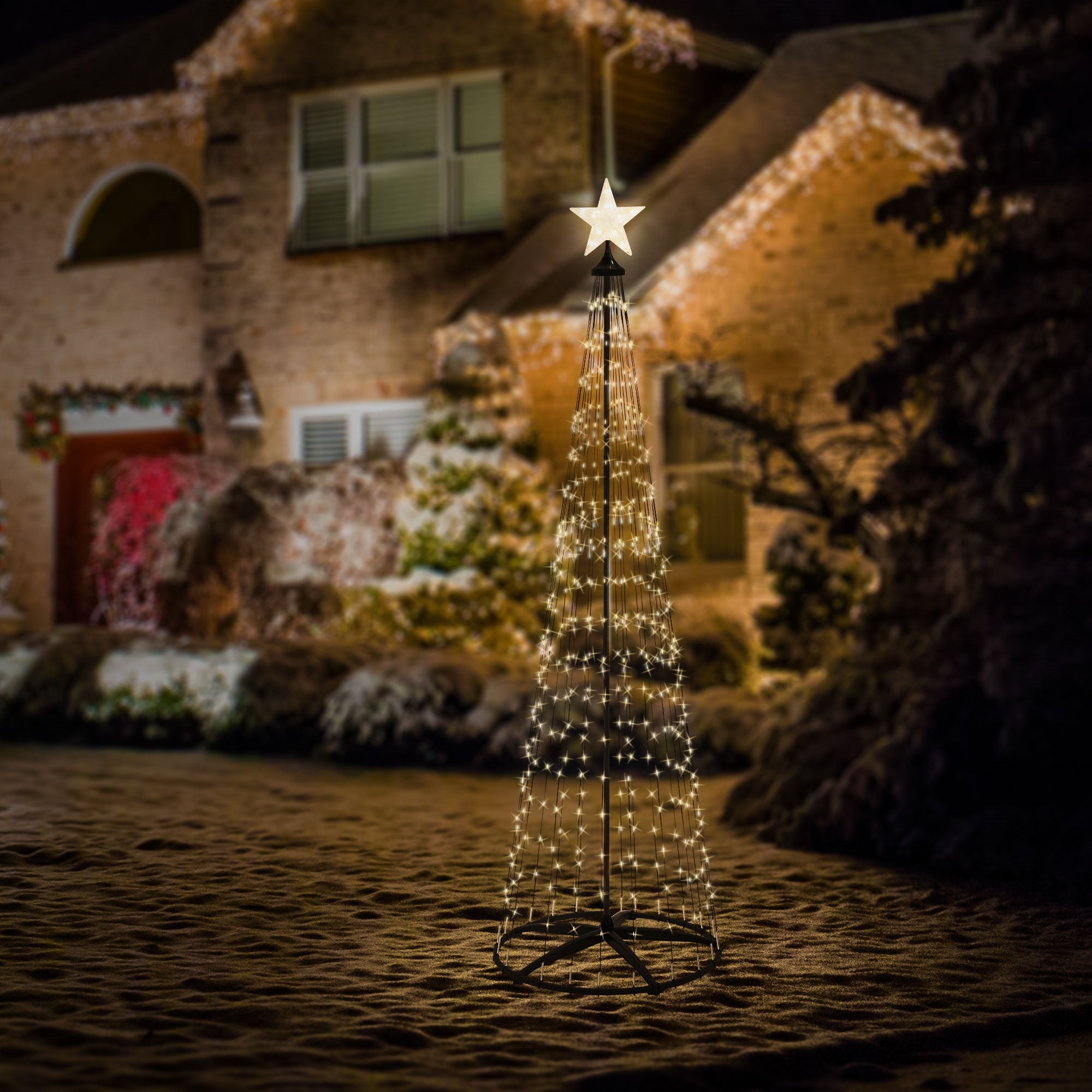 Illuminated Christmas tree made of lights in front of a house.