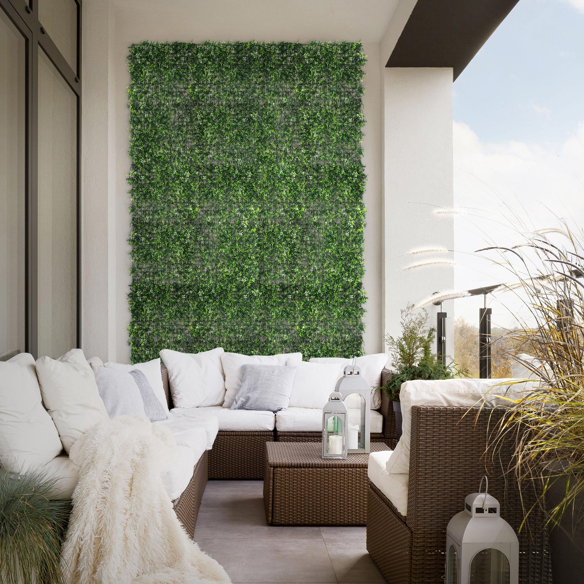 Balcon avec feuillage vert et coin salon confortable.