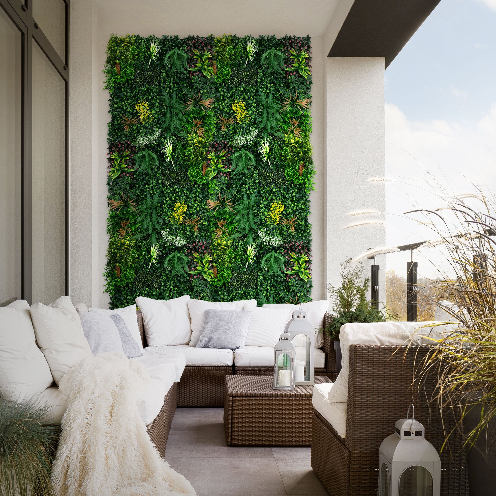 Balcon avec mur de plantes vertes, canapé et décoration, à la lumière du jour.