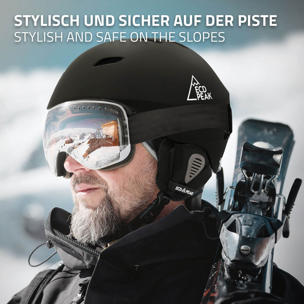 Mann mit schwarzem Skihelm und Brille auf der Piste, im Hintergrund Schnee und Berge.