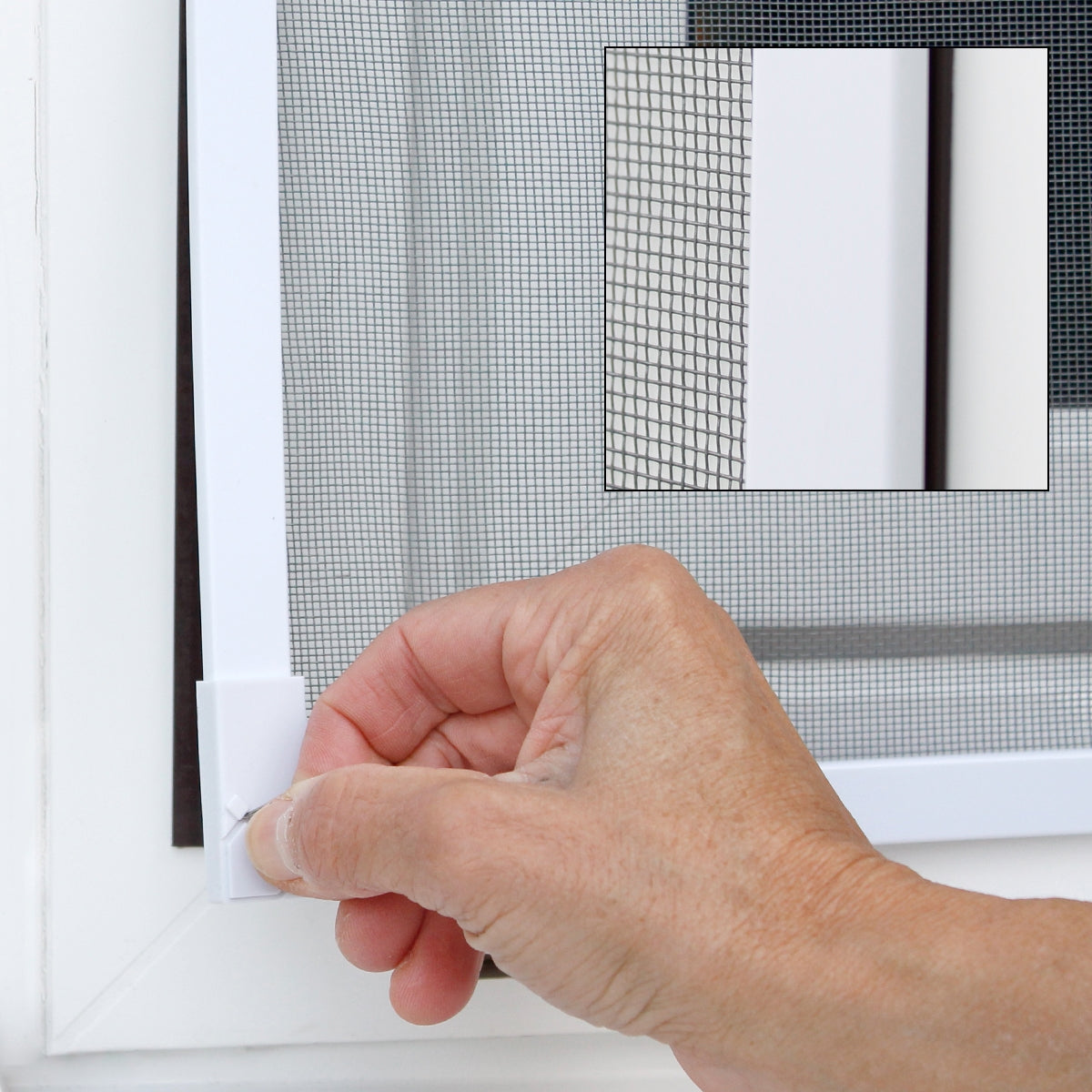 Hand touching a white frame with an insect screen.