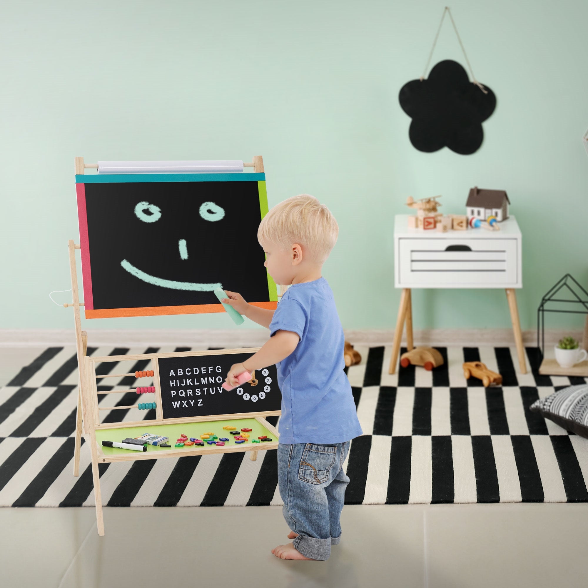 Small child drawing on a board with colorful chalk.