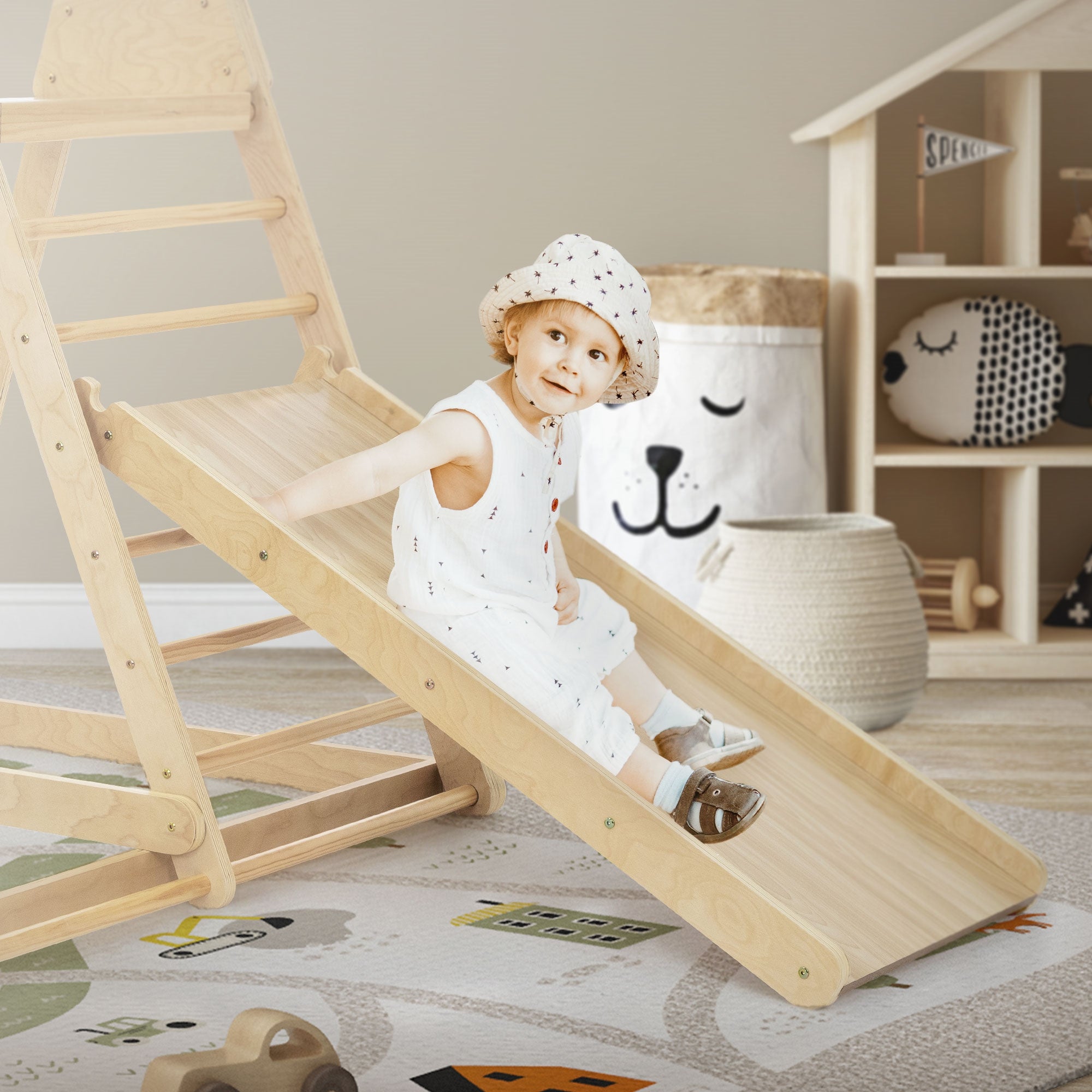 Enfant sur un toboggan, entouré de jouets et d'une pièce décorative.