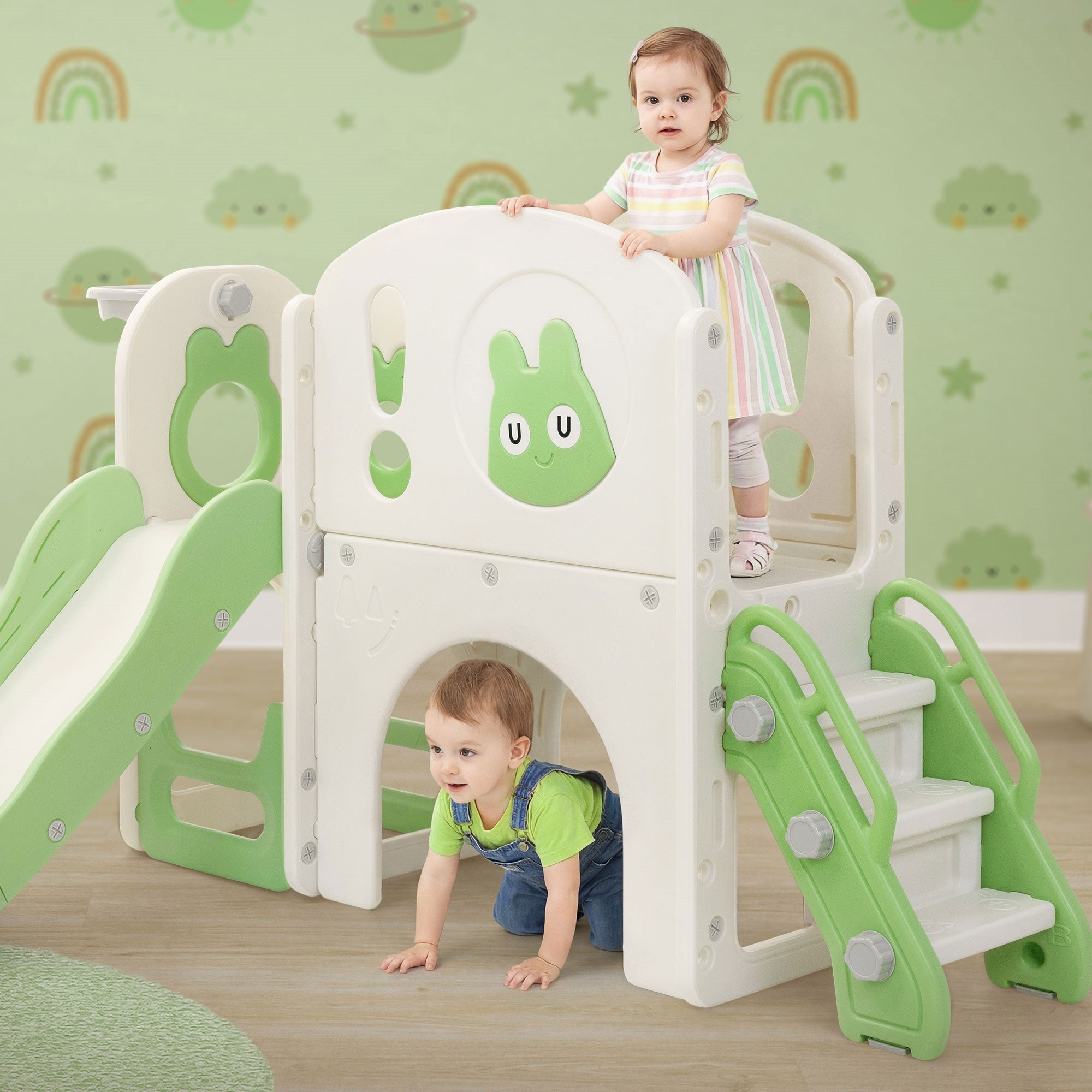Zwei Kinder spielen auf einem Spielturm mit Rutsche und Treppe.
