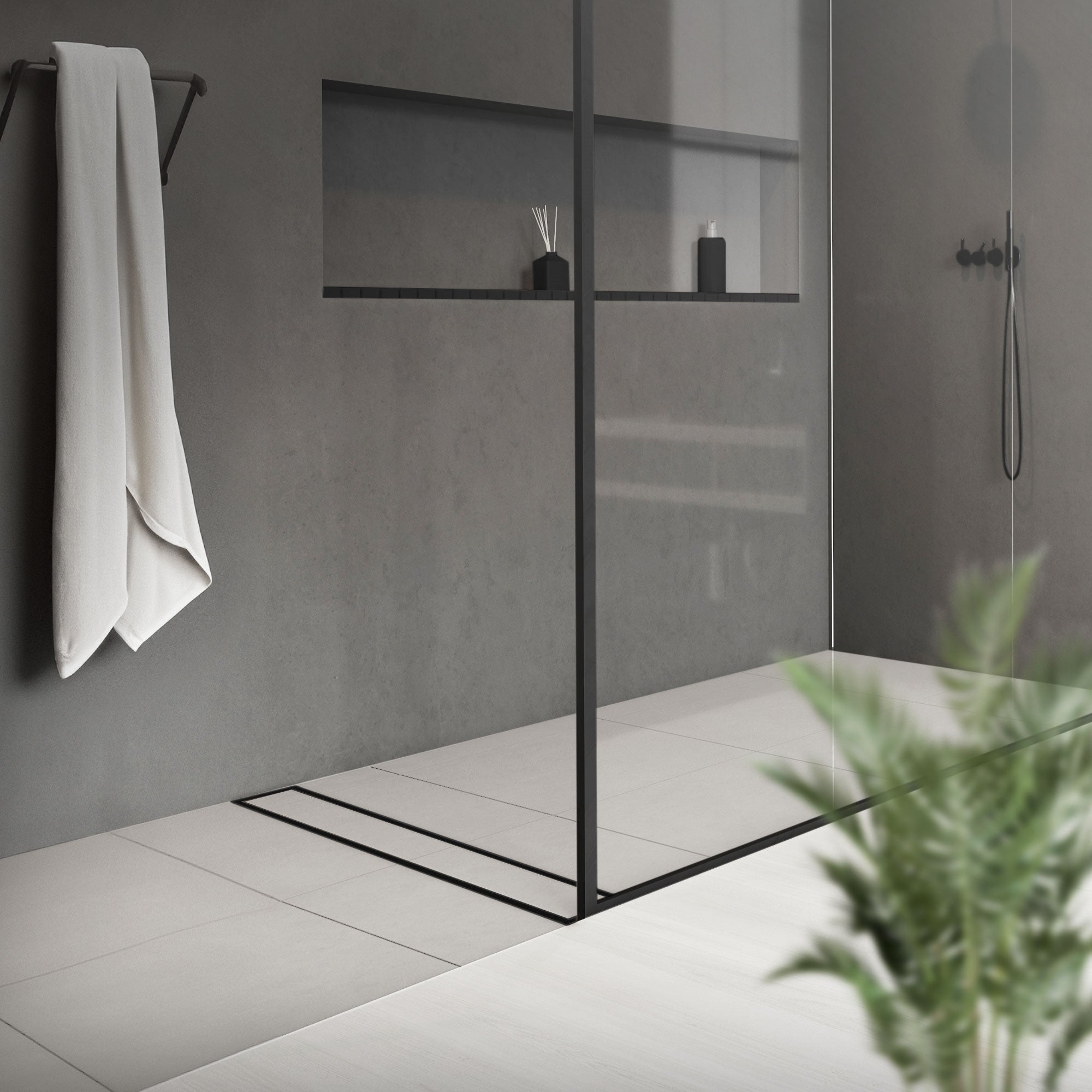 Moderne bruser med glasvæg, håndklædeholder og planter i forgrunden.