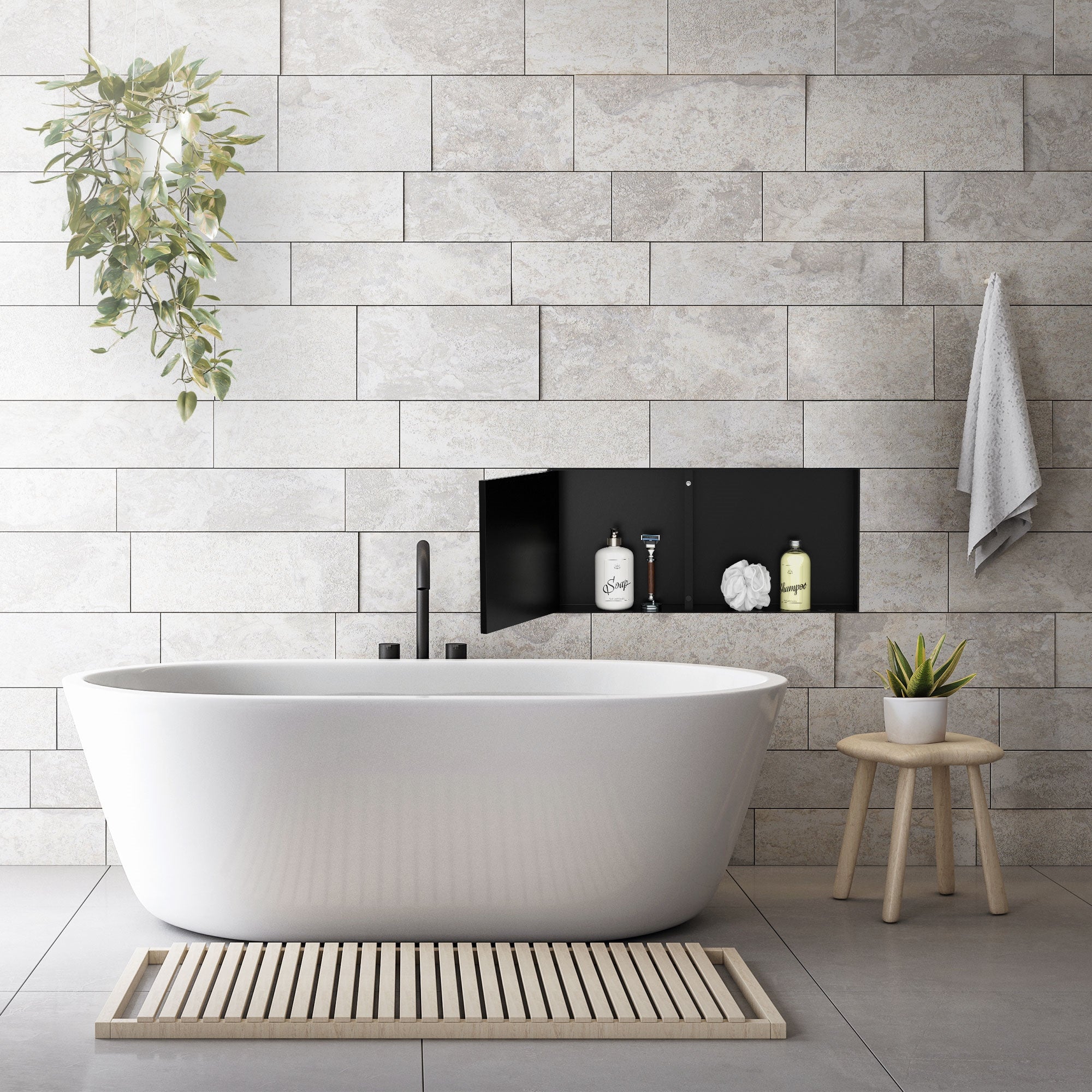 Freestanding bathtub in front of a stone wall with plants and personal care products.